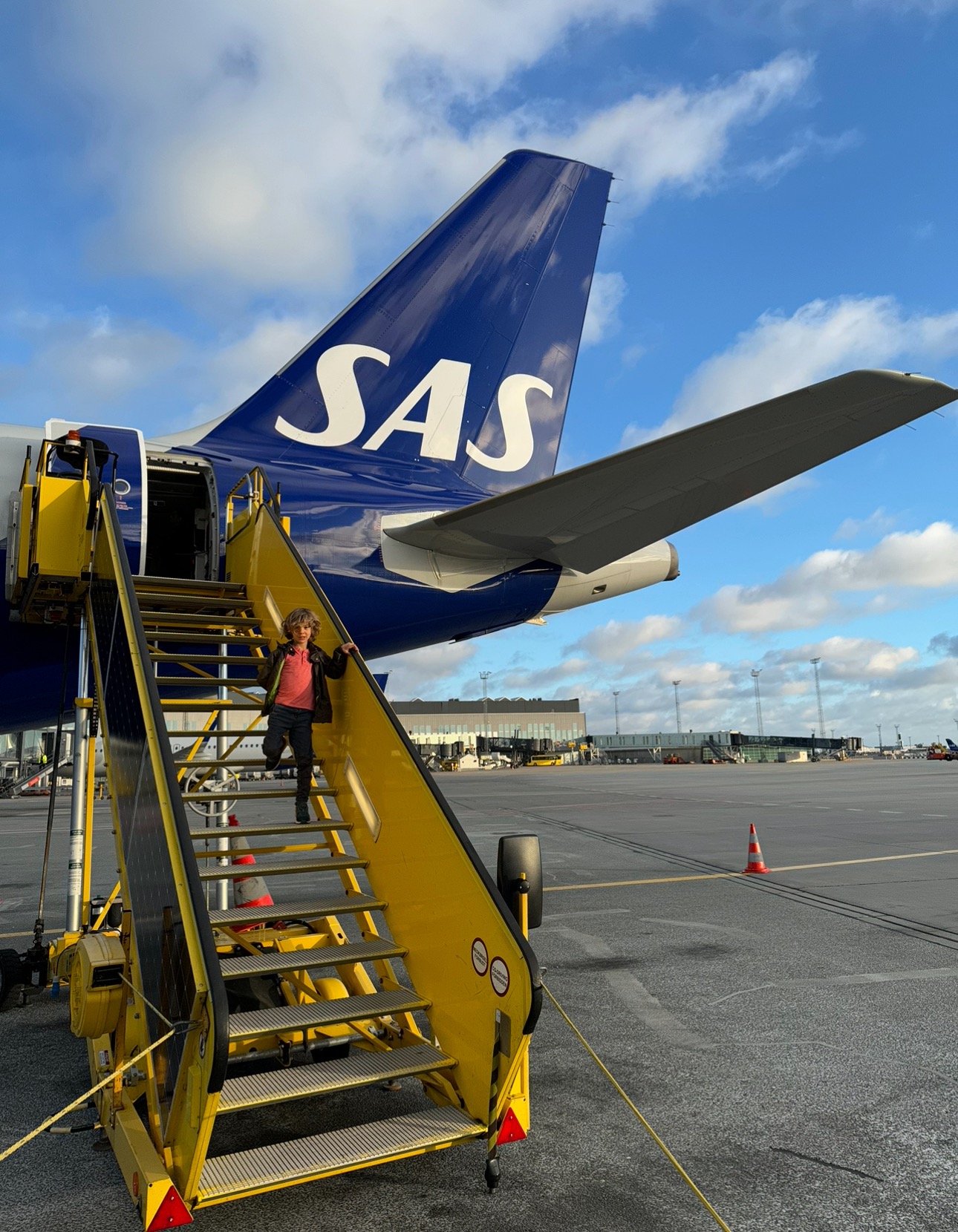 a child climbing up a yellow staircase to an airplane