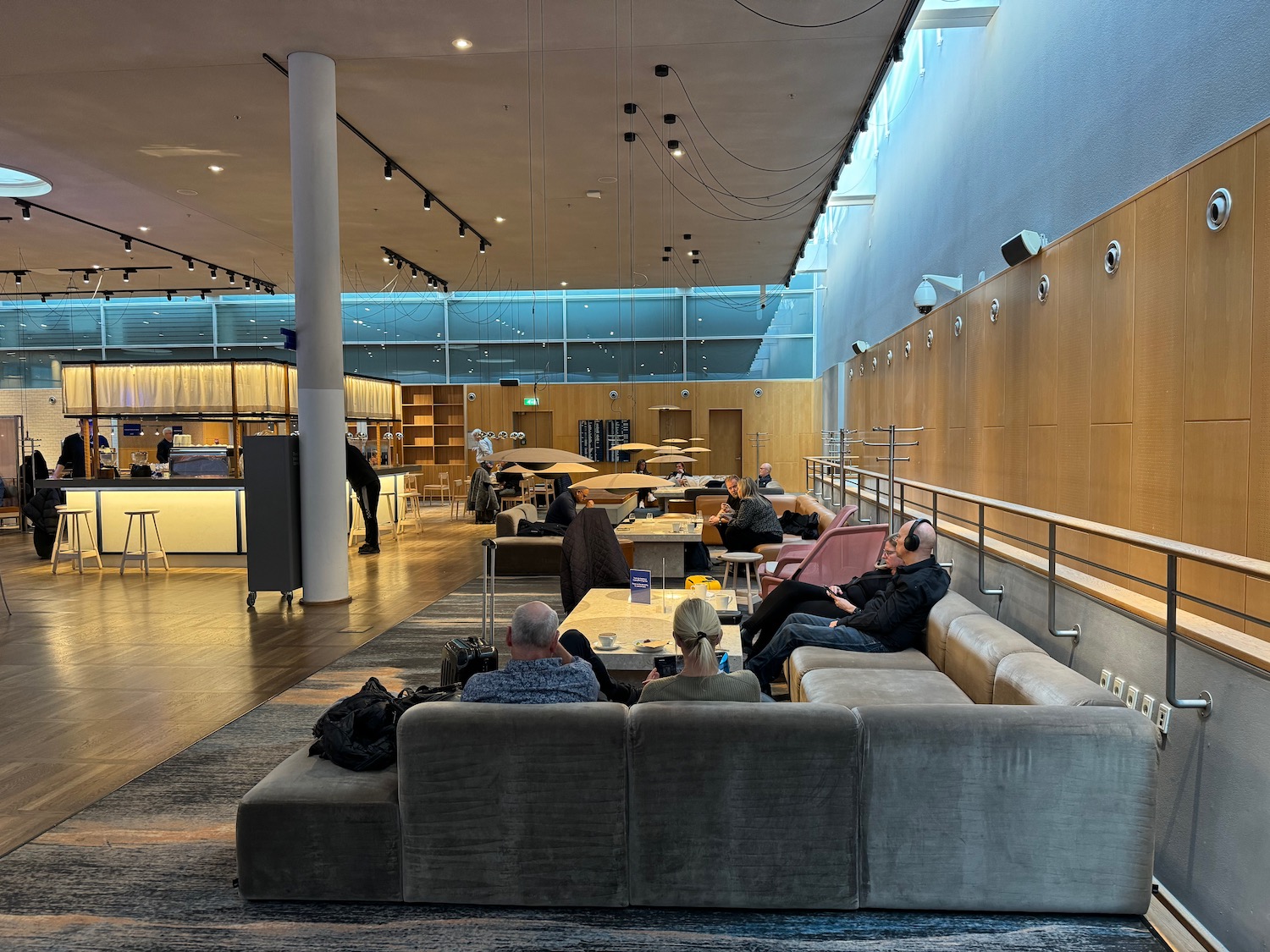 a group of people sitting on a couch in a room with a railing