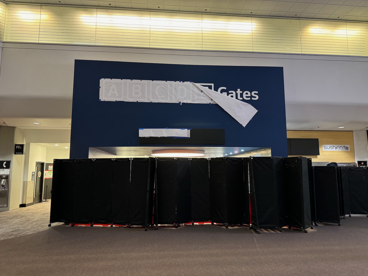 a row of black screens in front of a blue wall