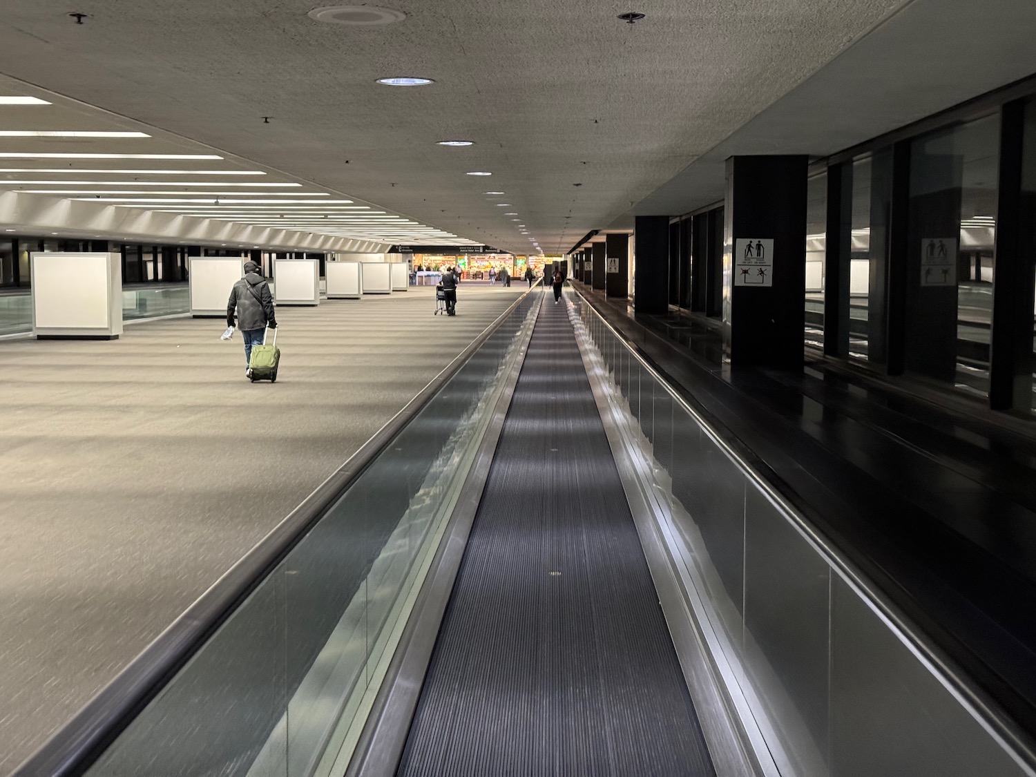 a group of people walking on an airport walkway