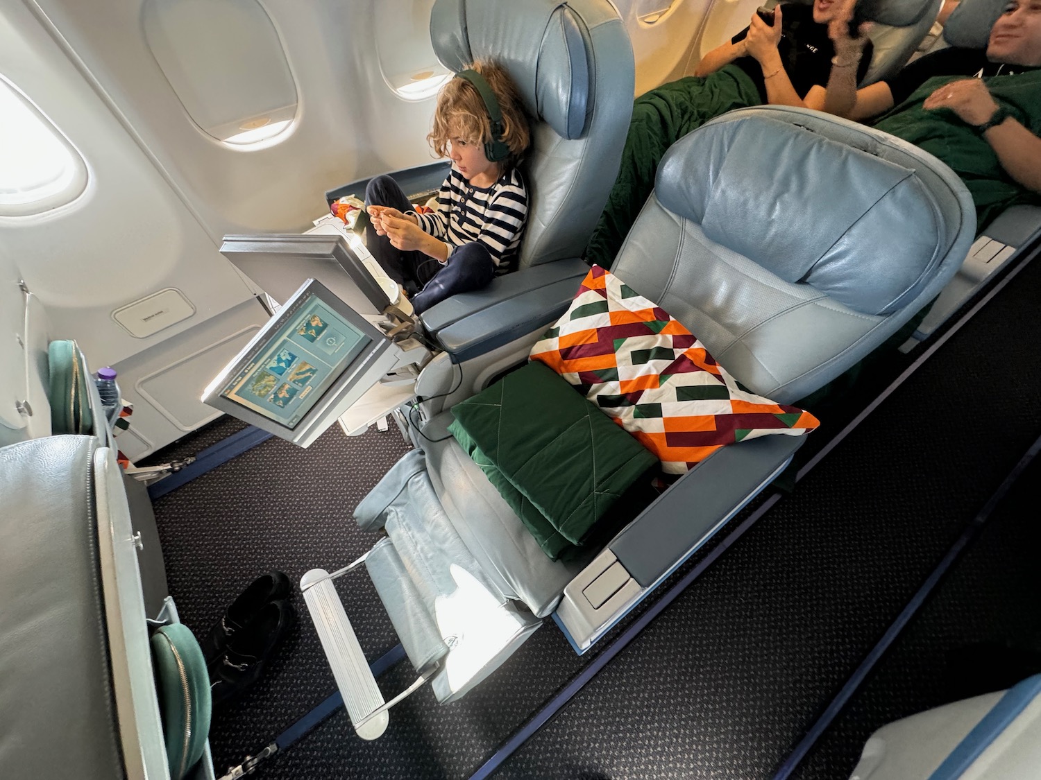 a child sitting in a chair on an airplane