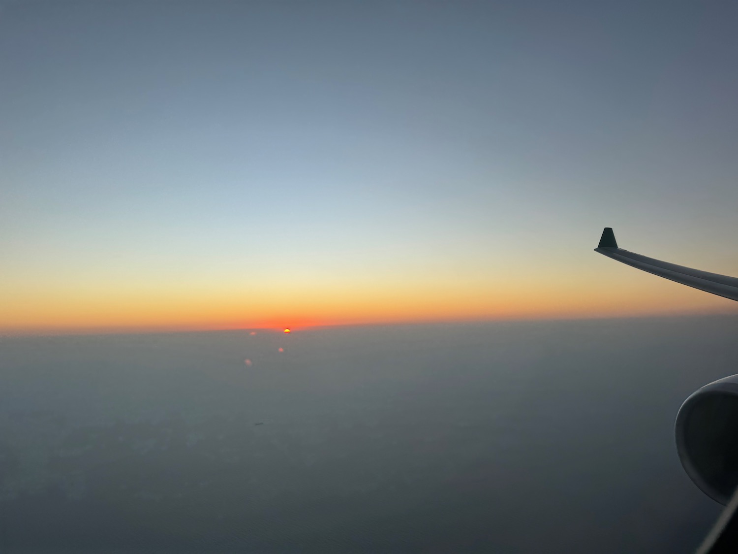 a wing of an airplane flying in the sky