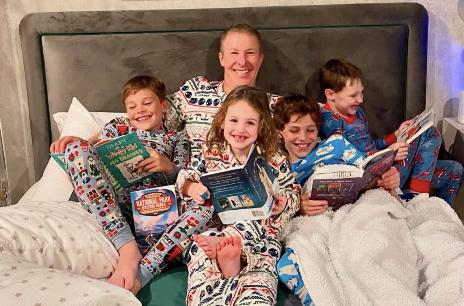 a man and children in pajamas reading books