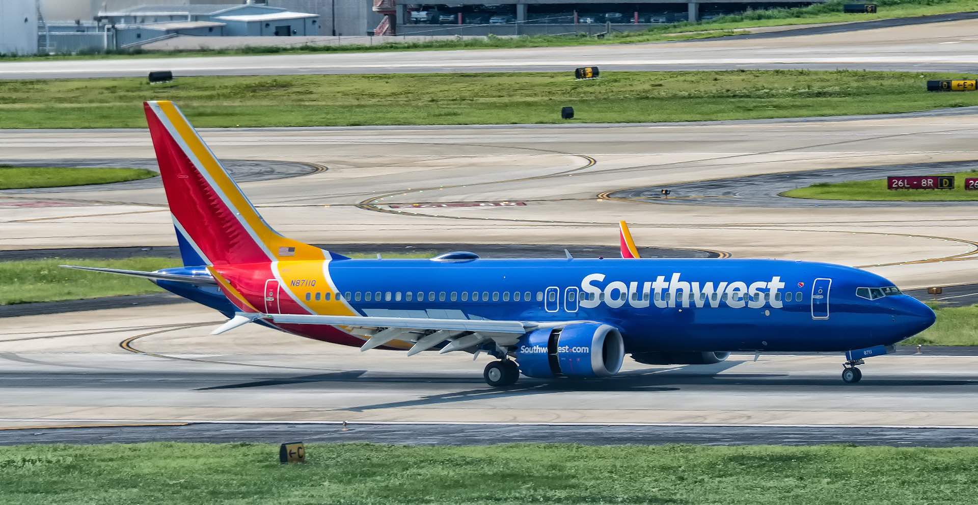 a blue and red airplane on a runway