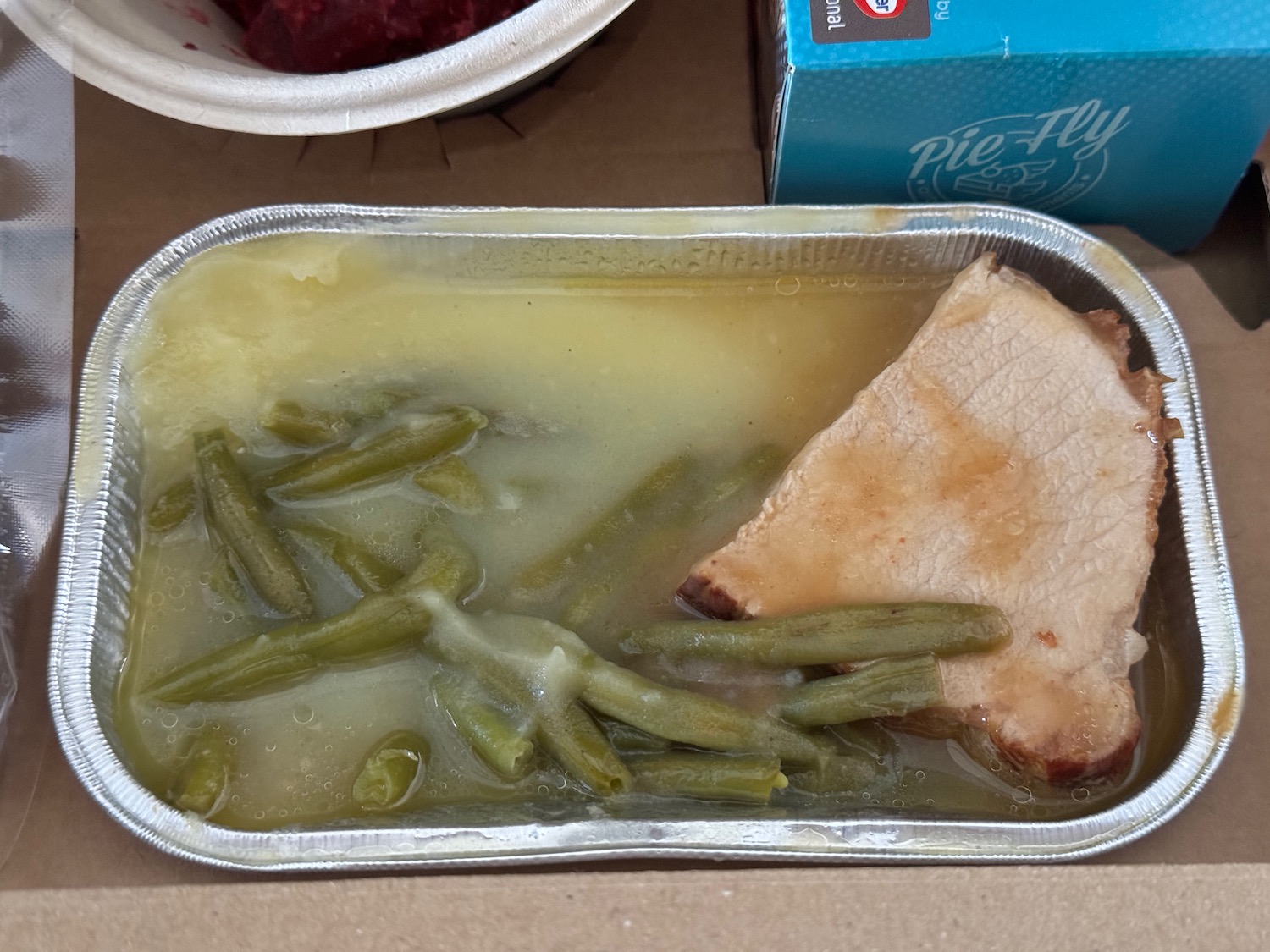 a tray of food with meat and green beans