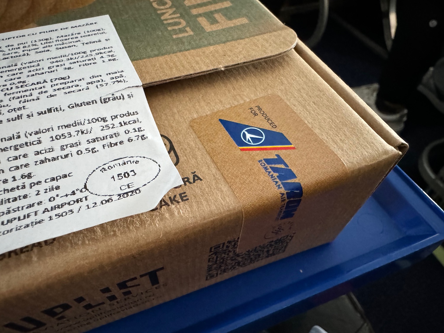 a cardboard box with a receipt on a blue tray