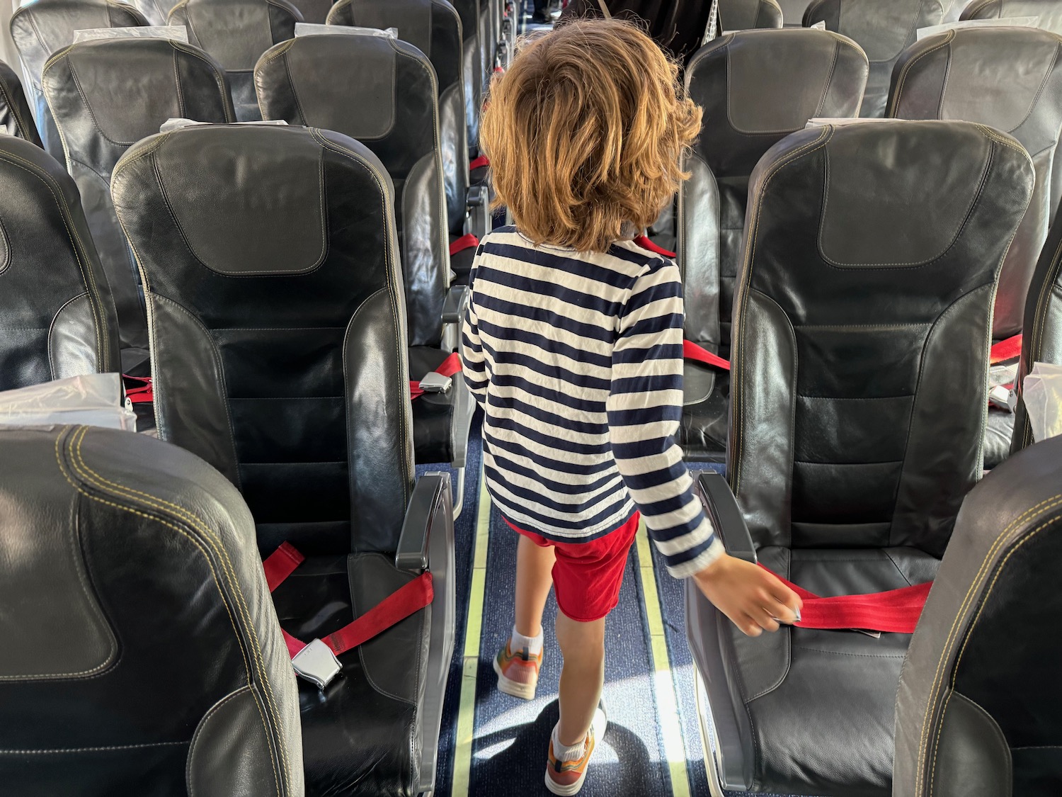 a child walking on an airplane seat