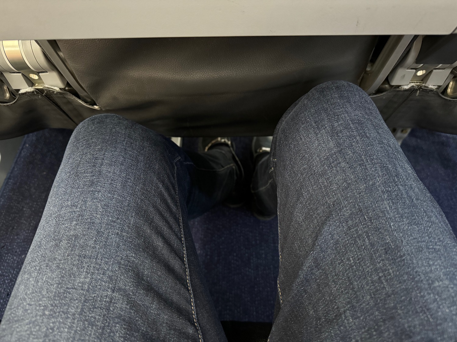 a person's legs and feet in a seat