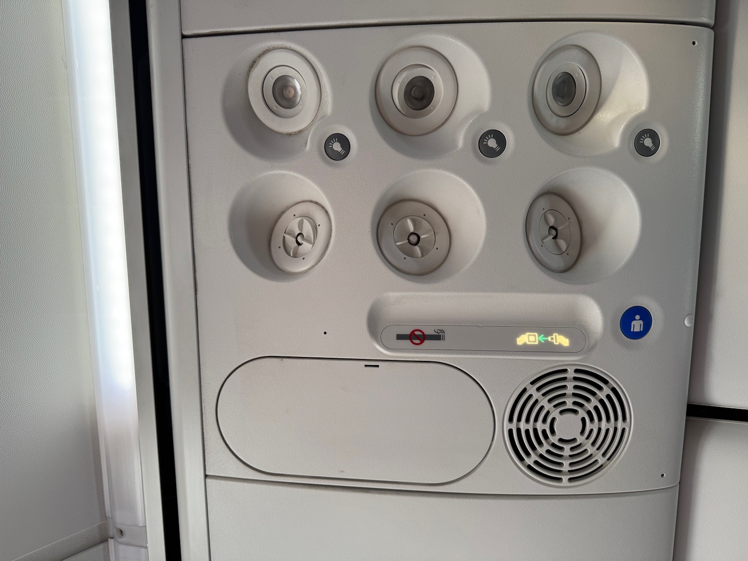 a white panel with circular holes and buttons