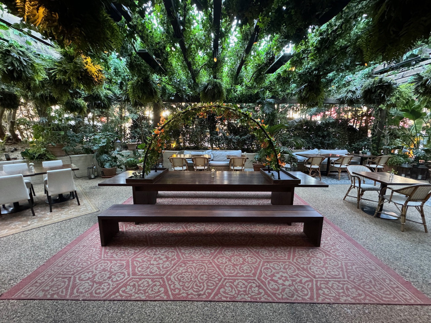 a table and benches under a canopy of trees