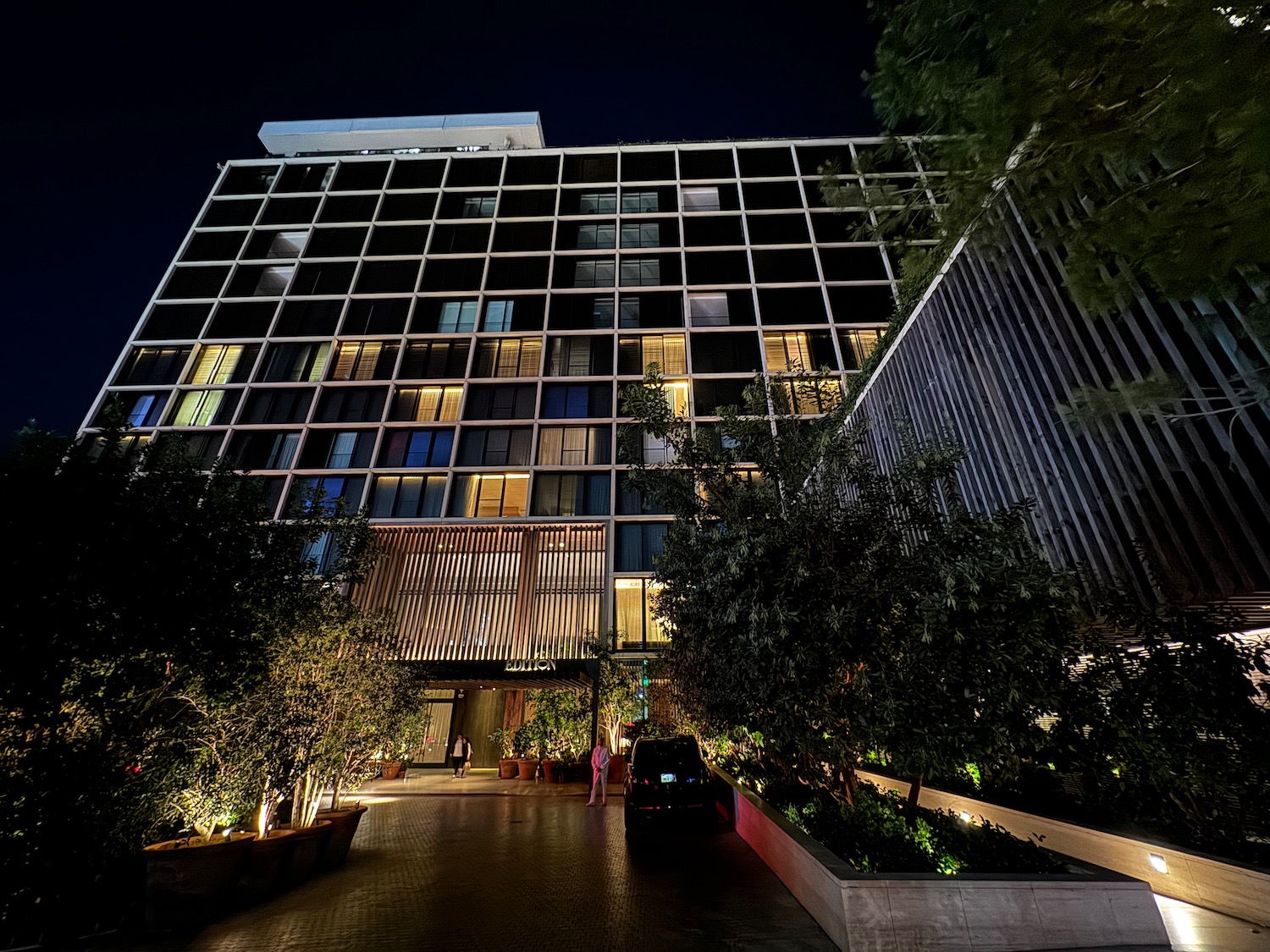 a building with trees and plants in front of it