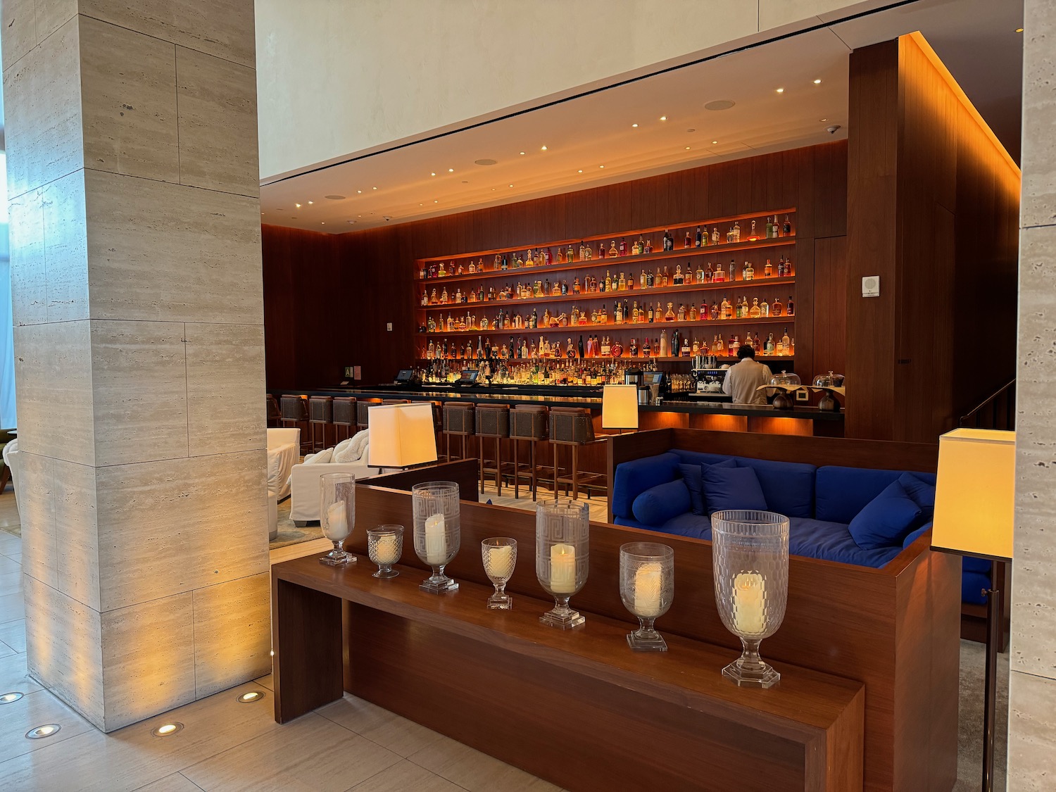 a bar with a blue couch and candles on a table