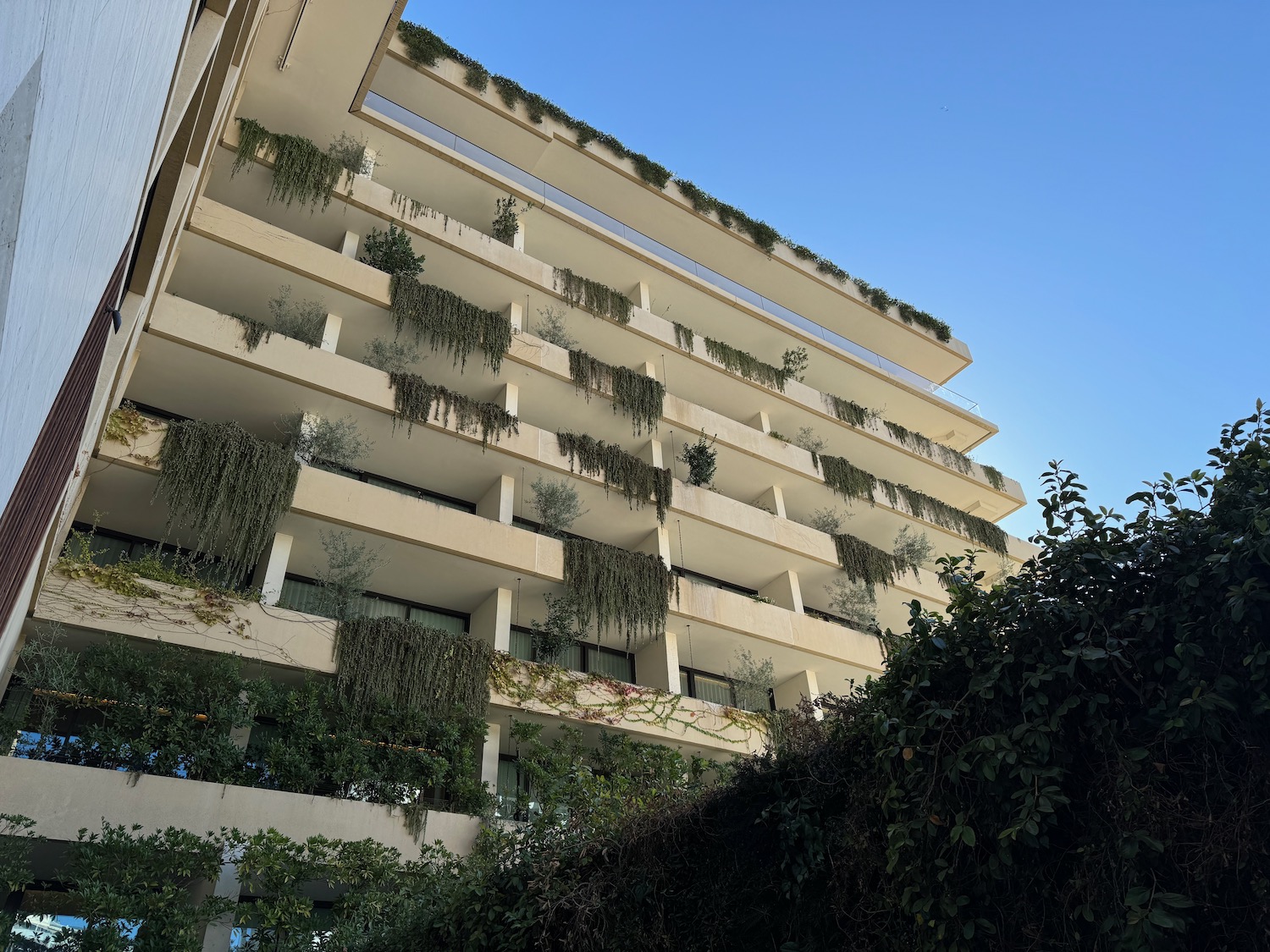 a building with plants on the balconies