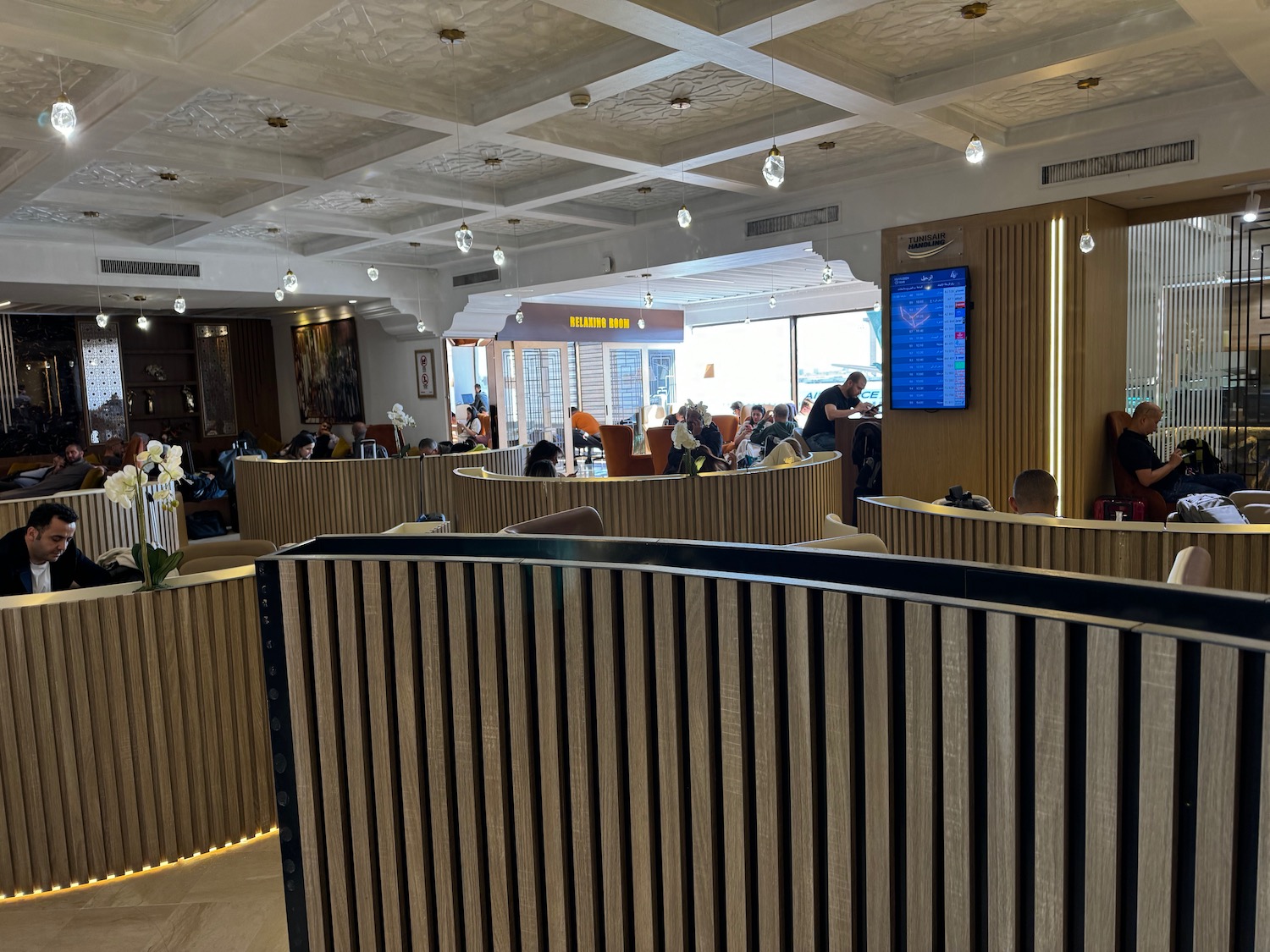 a room with a large screen and people sitting at tables