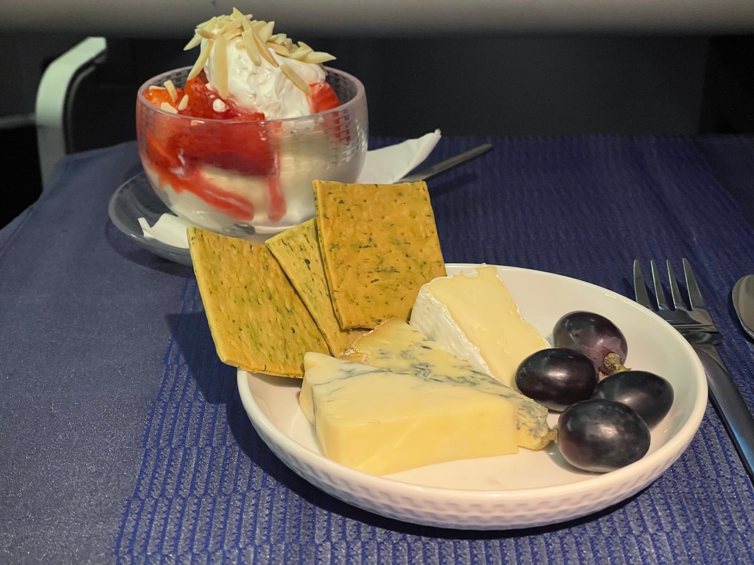 a plate of cheese and grapes on a table