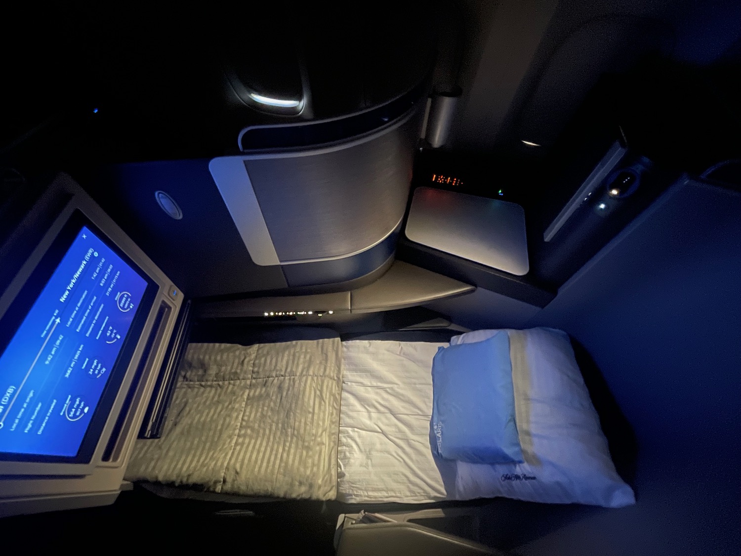 a bed and a monitor in a plane