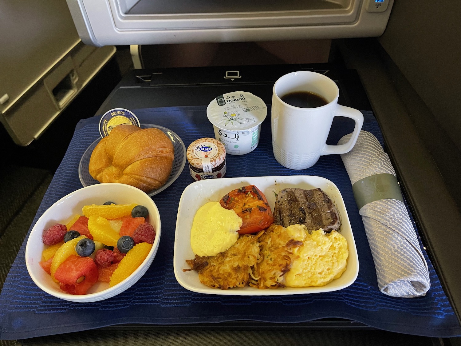 a tray of food and a cup of coffee on a table