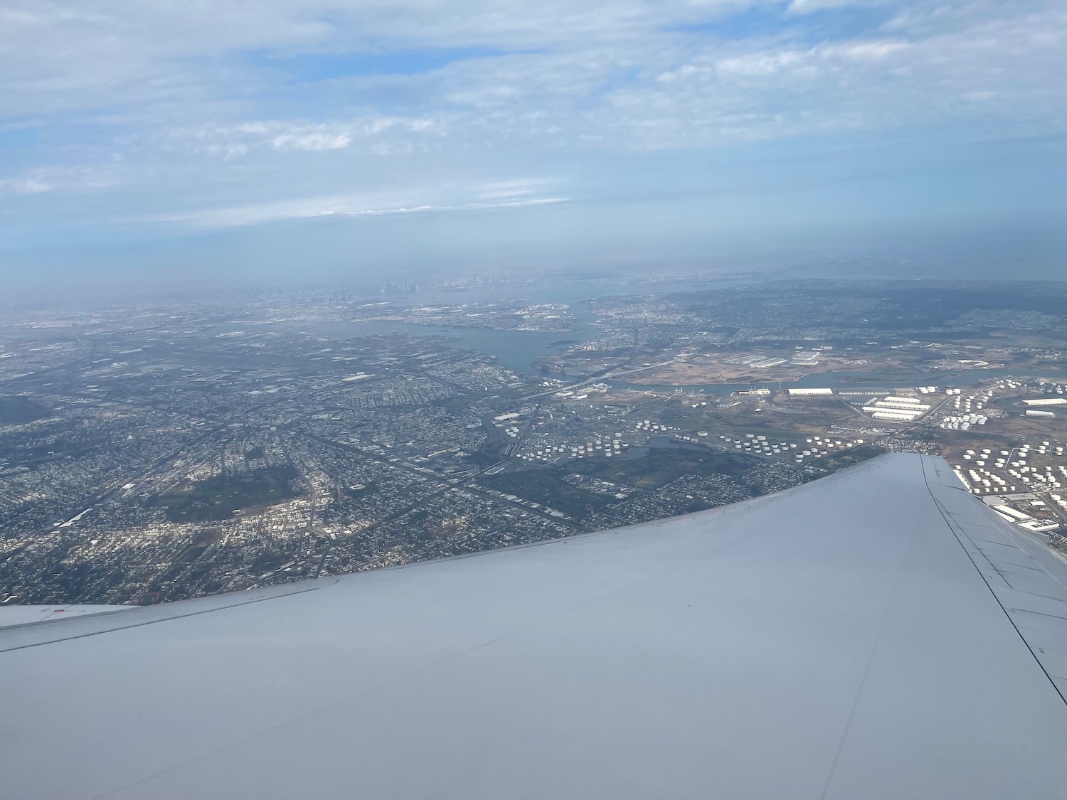 an airplane wing with a city in the background