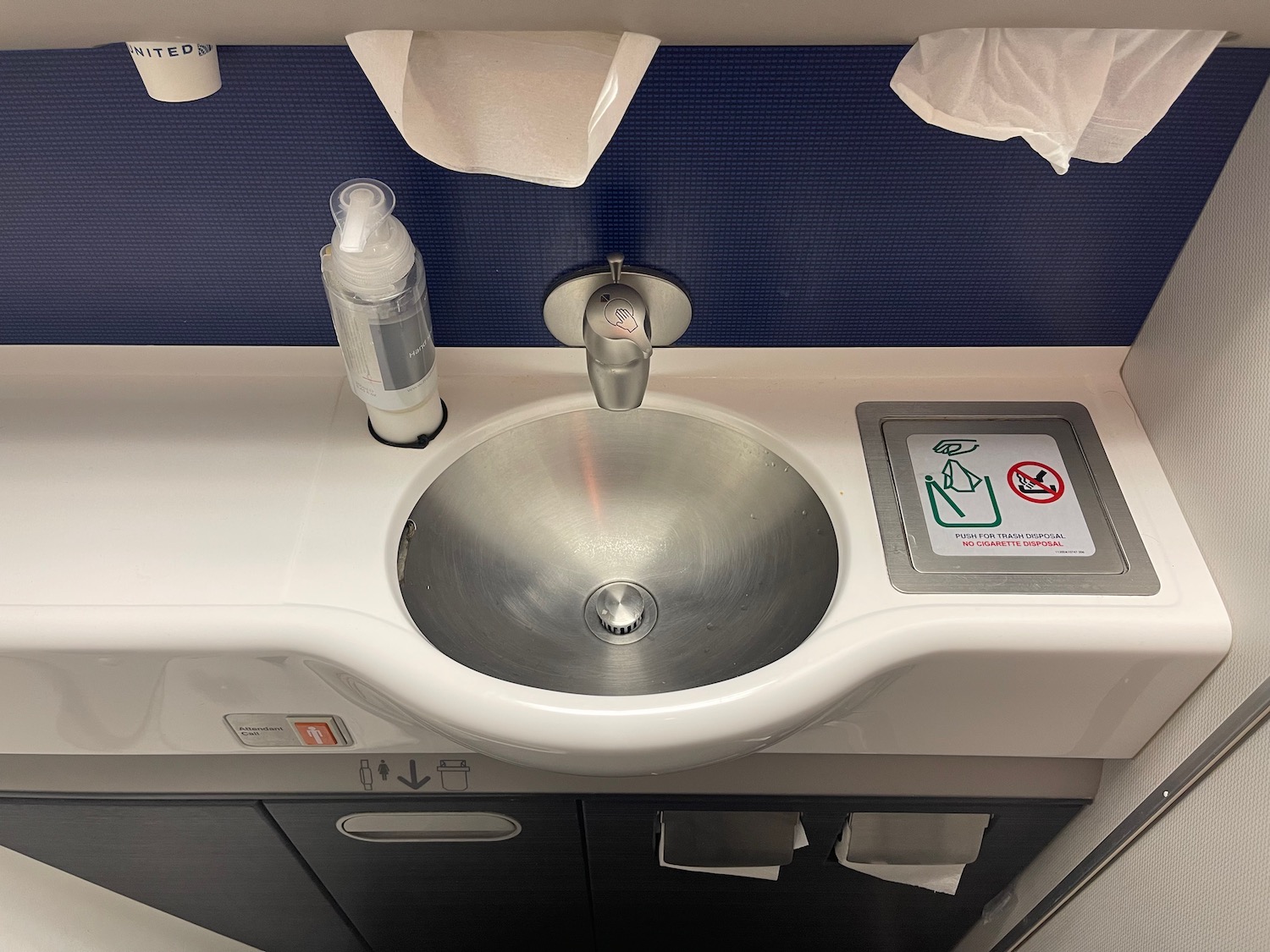 a sink with a soap dispenser and a bottle of liquid