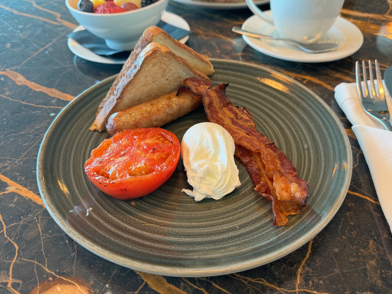 a plate of food with a tomato and bacon