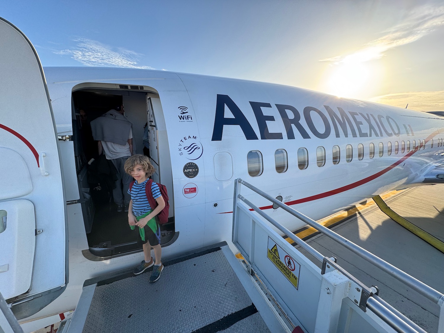 a boy standing in the door of an airplane