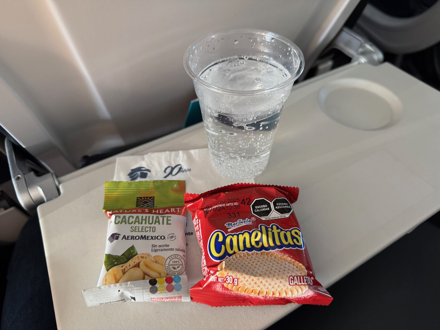 a glass of water and a bag of chips on a table