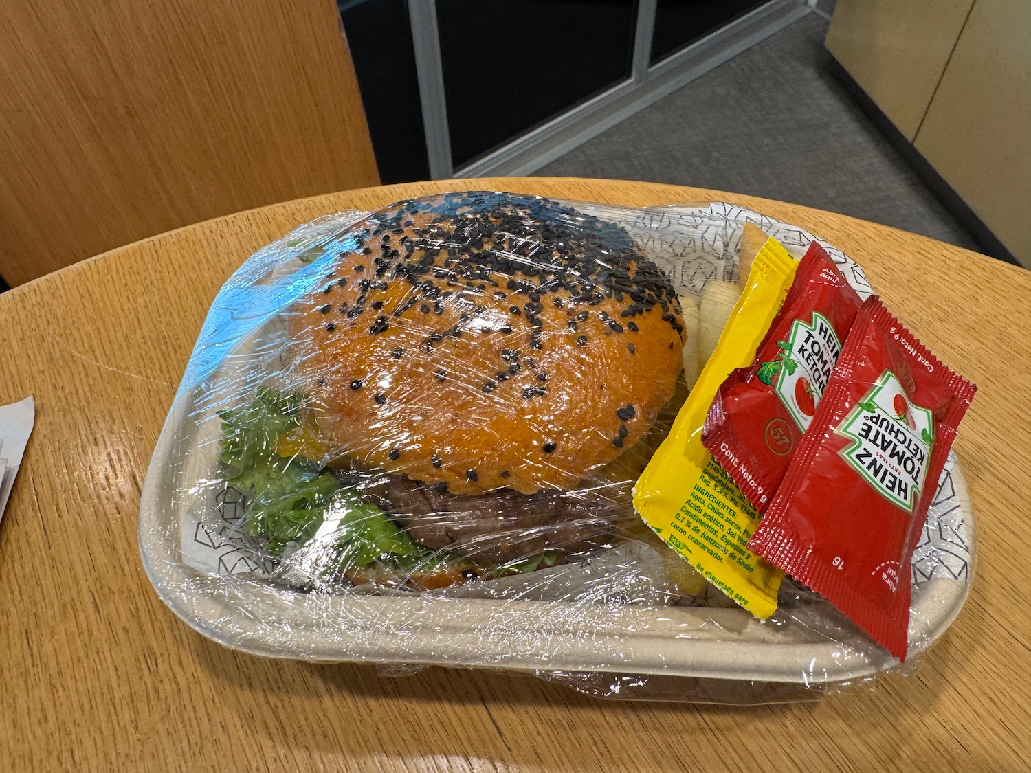 a hamburger and chips in a plastic wrapper