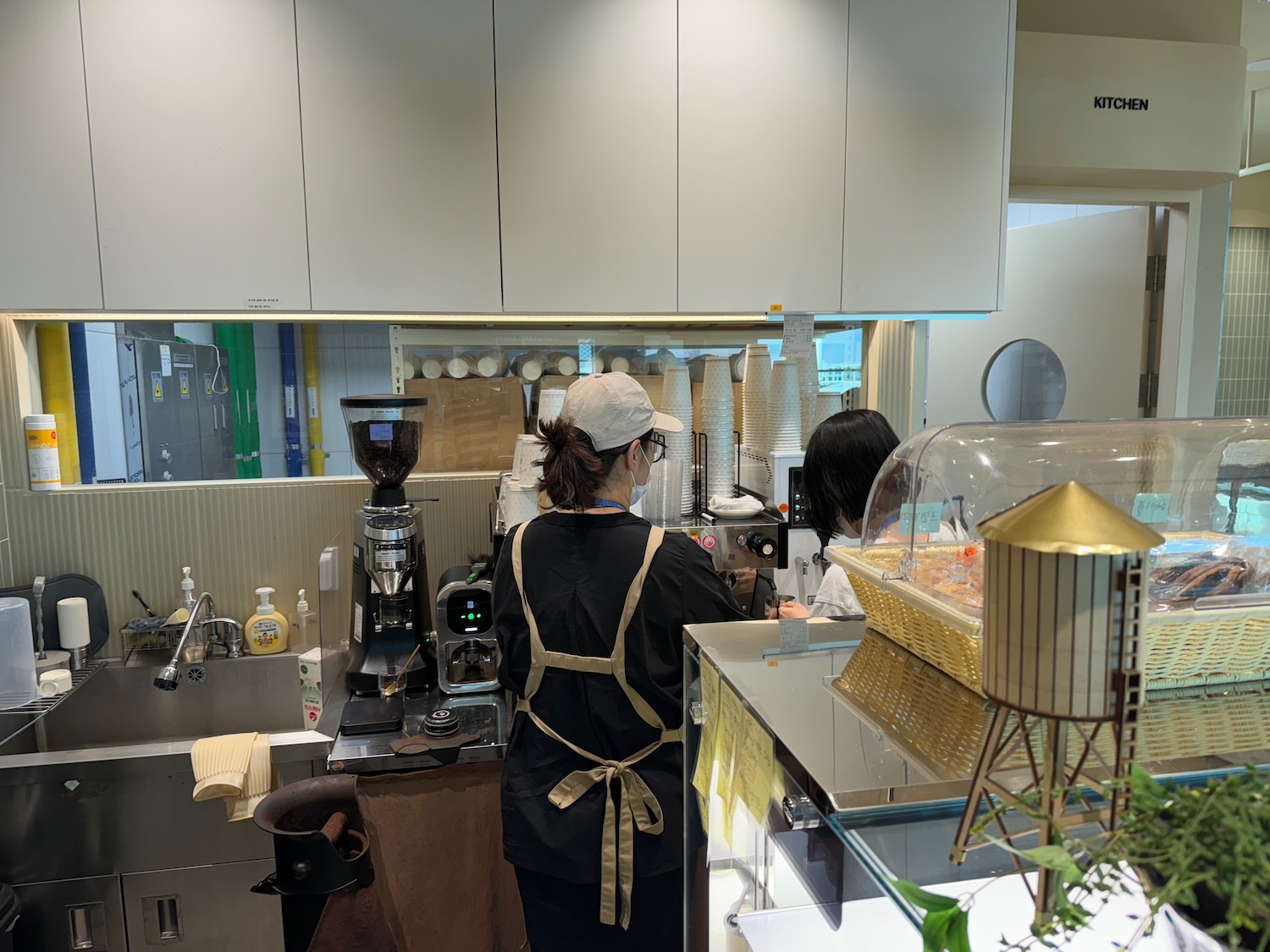 a woman standing behind a counter in a coffee shop