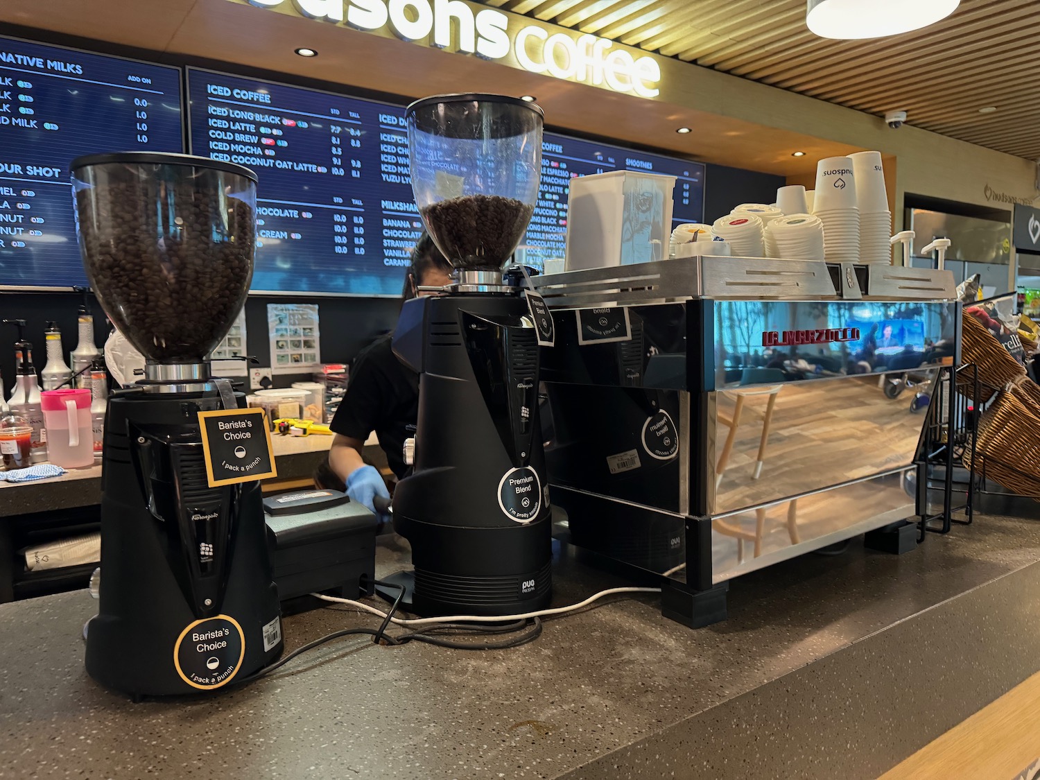 a coffee machine with coffee beans in front of a screen