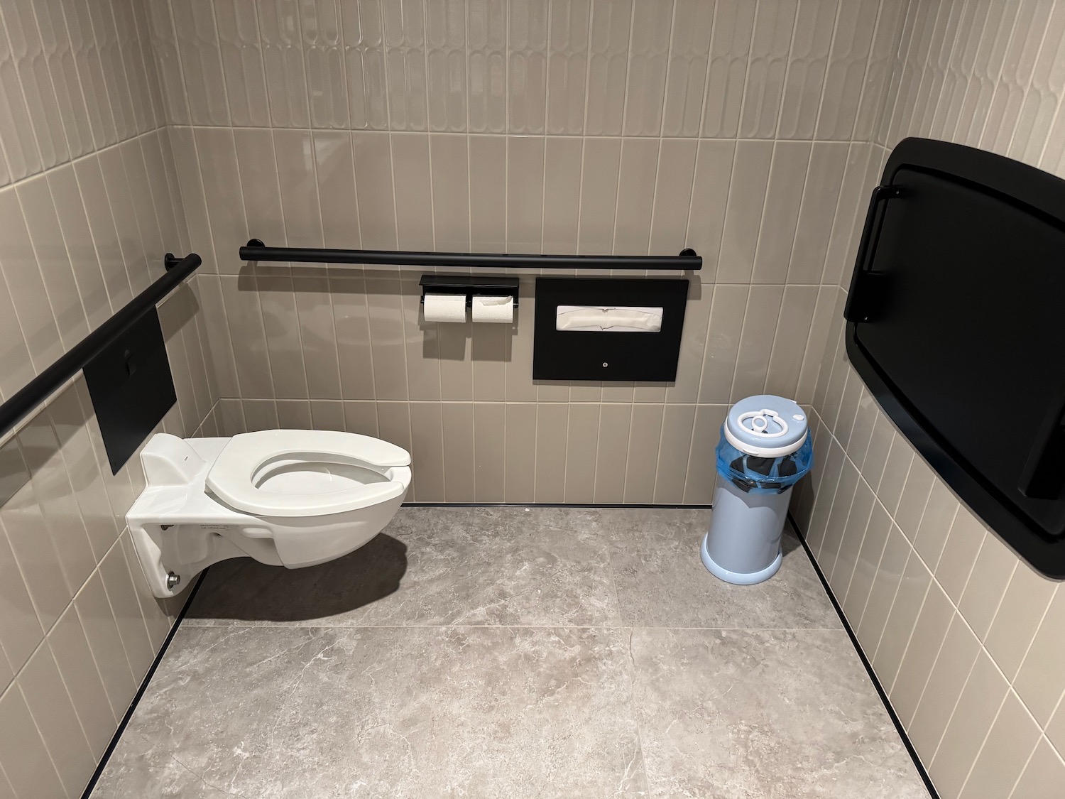 a bathroom with a toilet and a trash can