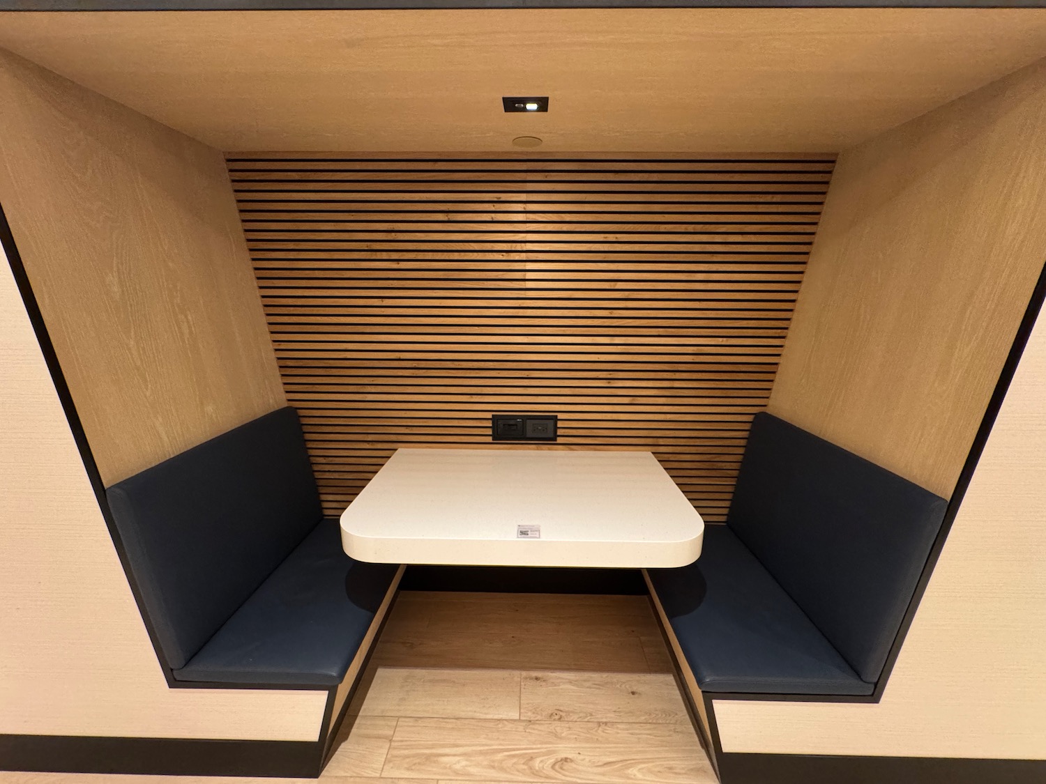 a table and two blue seats in a booth