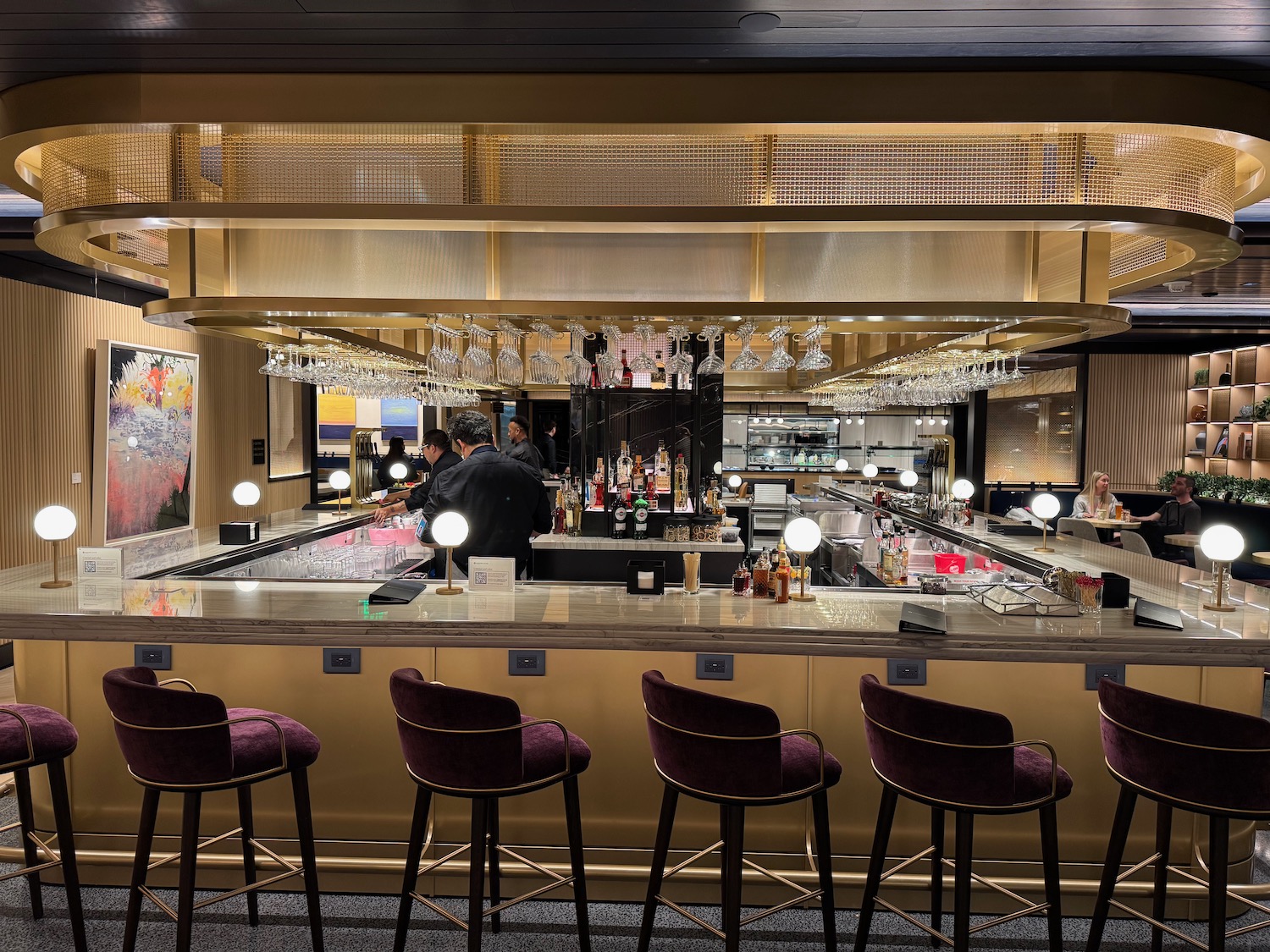 a bar with wine glasses and a man behind it