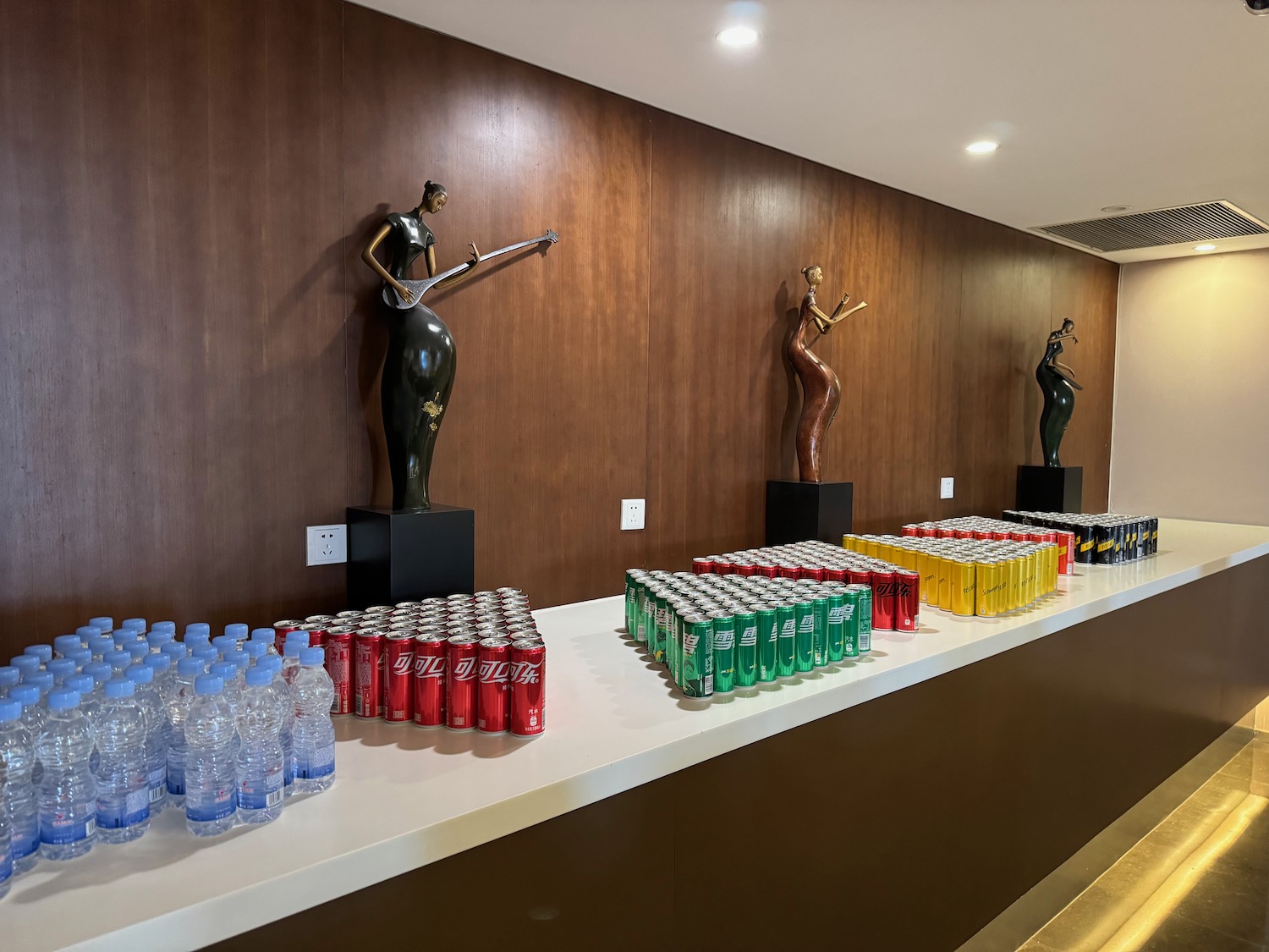 a row of drinks and statues on a table