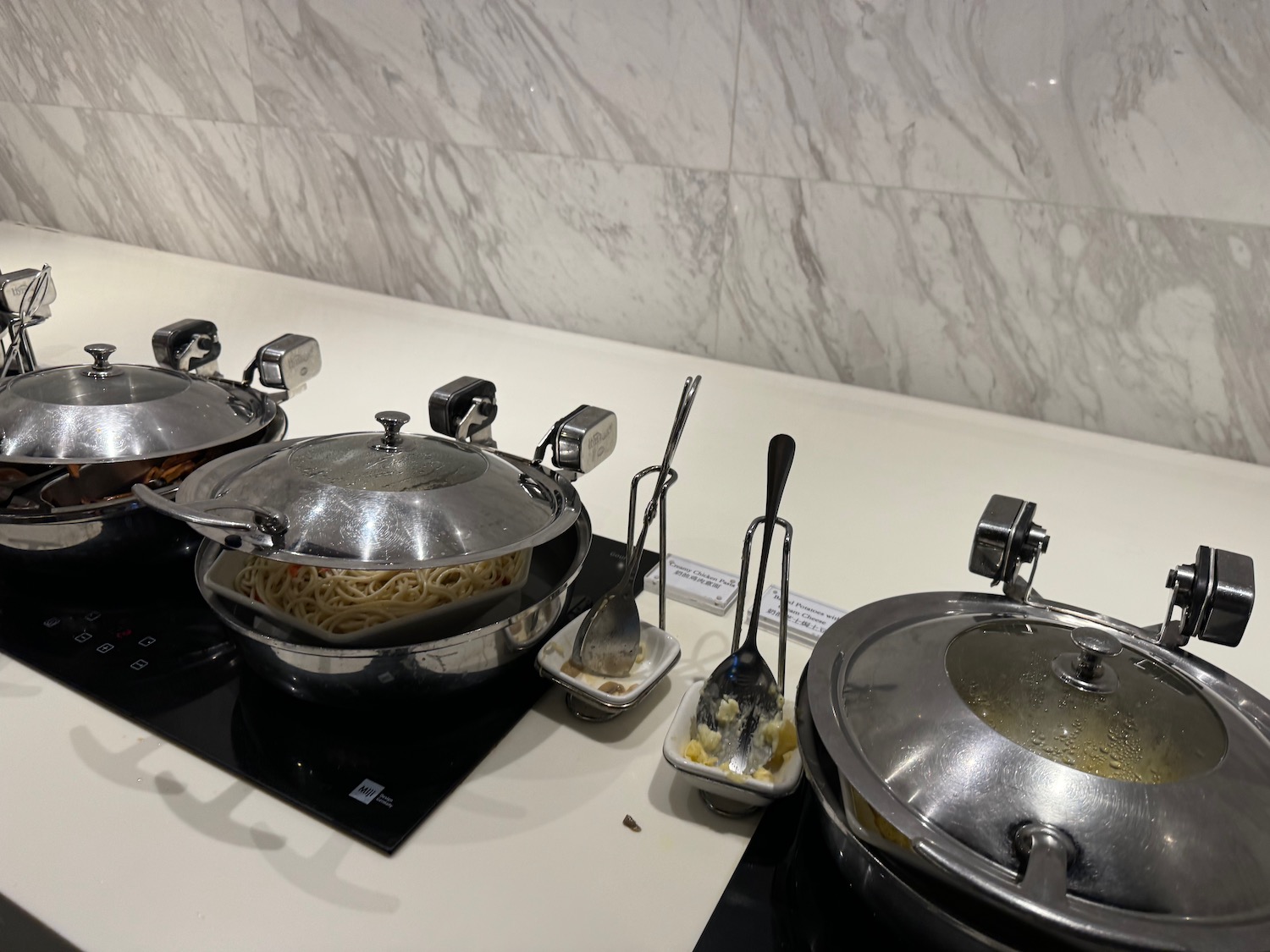 a row of pots with food on a counter