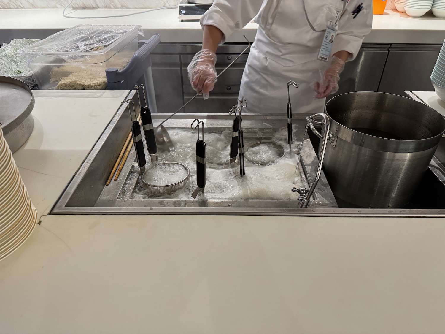 a person in a white coat cooking in a sink