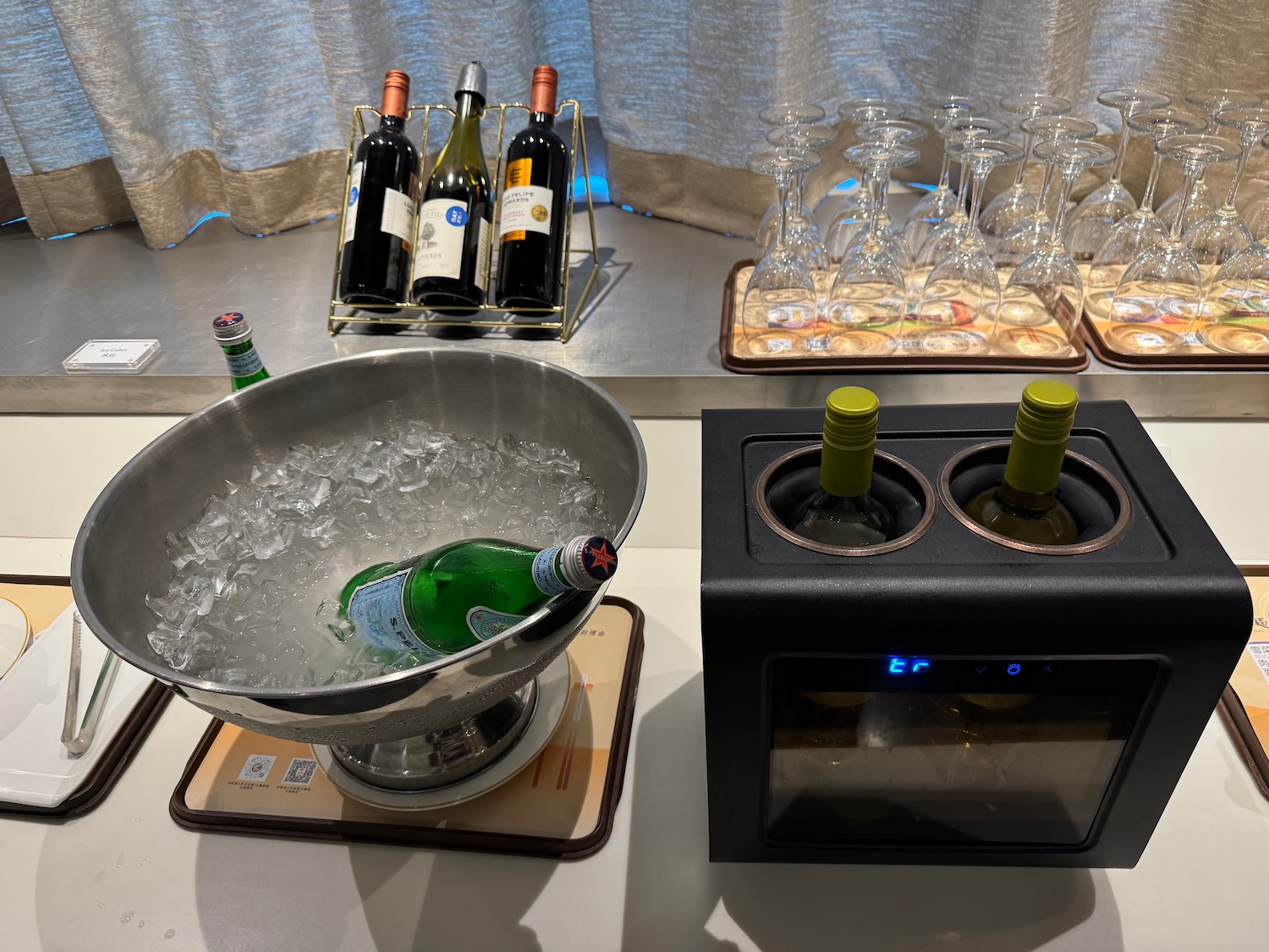 a group of wine glasses and a bowl of ice on a table