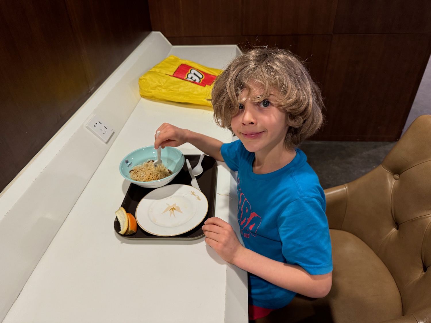 a boy sitting at a table eating food