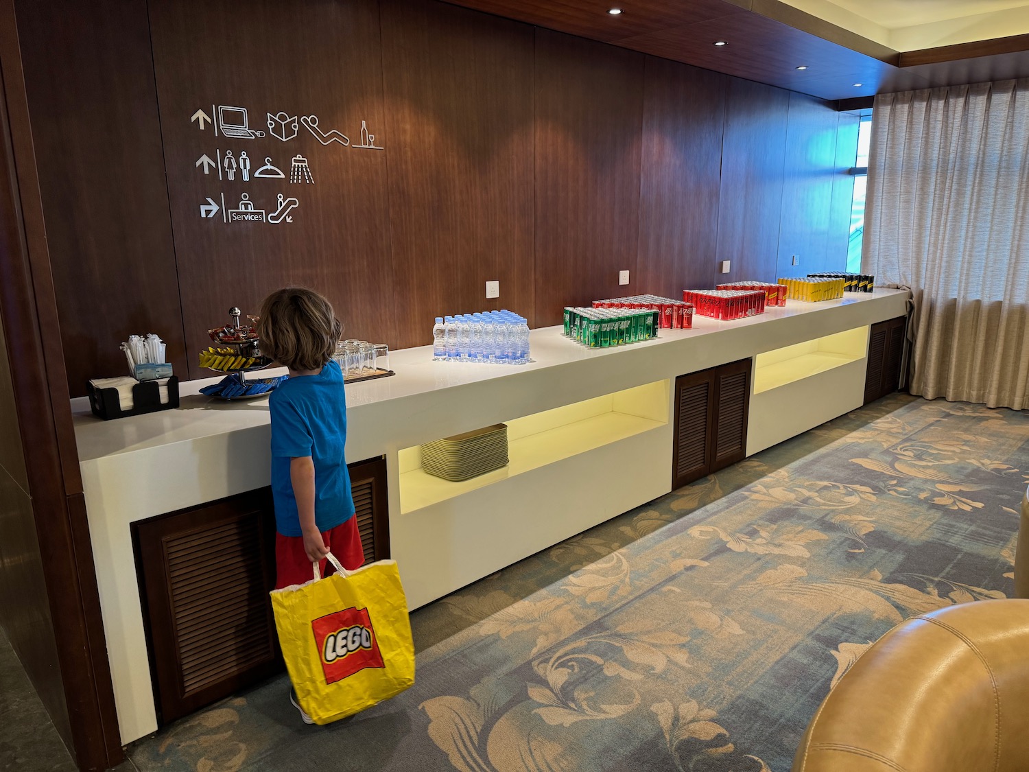 a child standing at a counter with a bag and plastic bottles