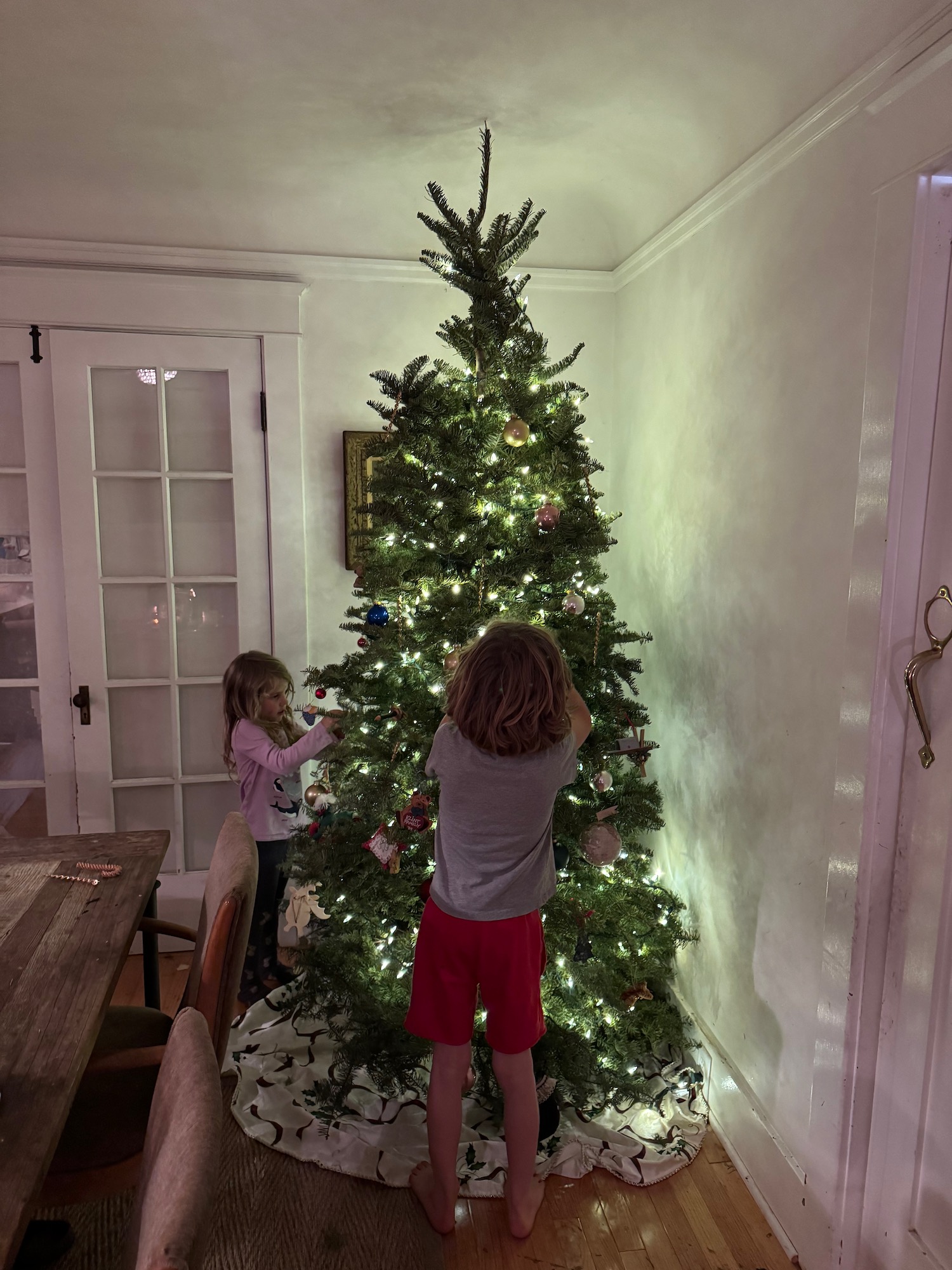 a children standing by a christmas tree