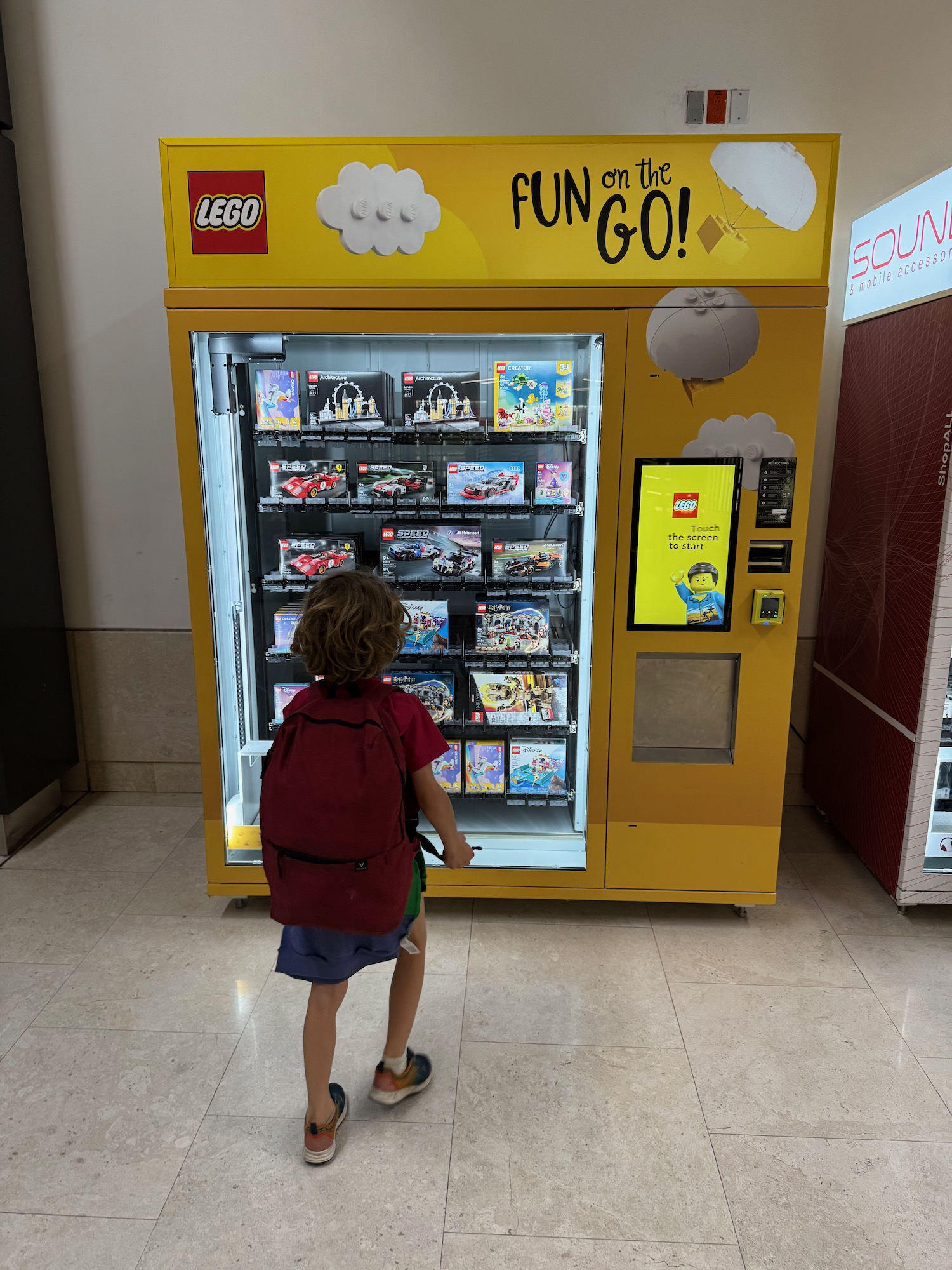 a child standing in front of a vending machine