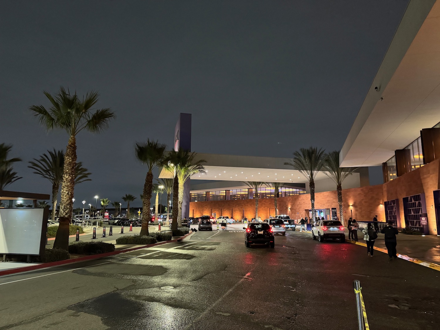 a building with palm trees and cars on the street