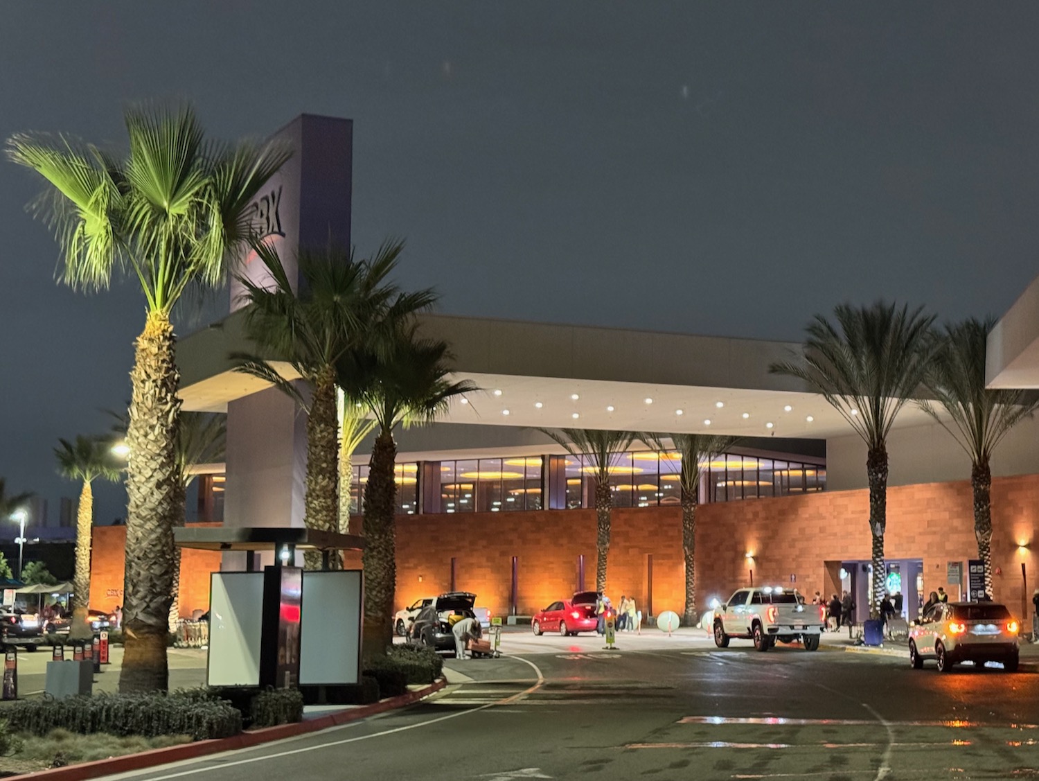 a building with palm trees and cars