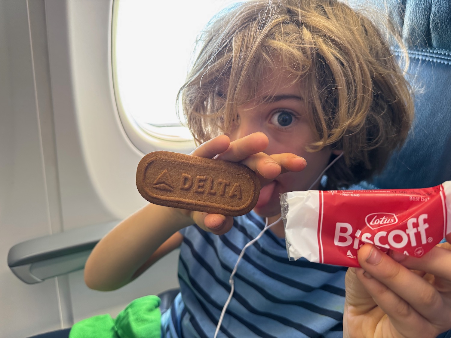 a child holding a cookie and a package of biscuit