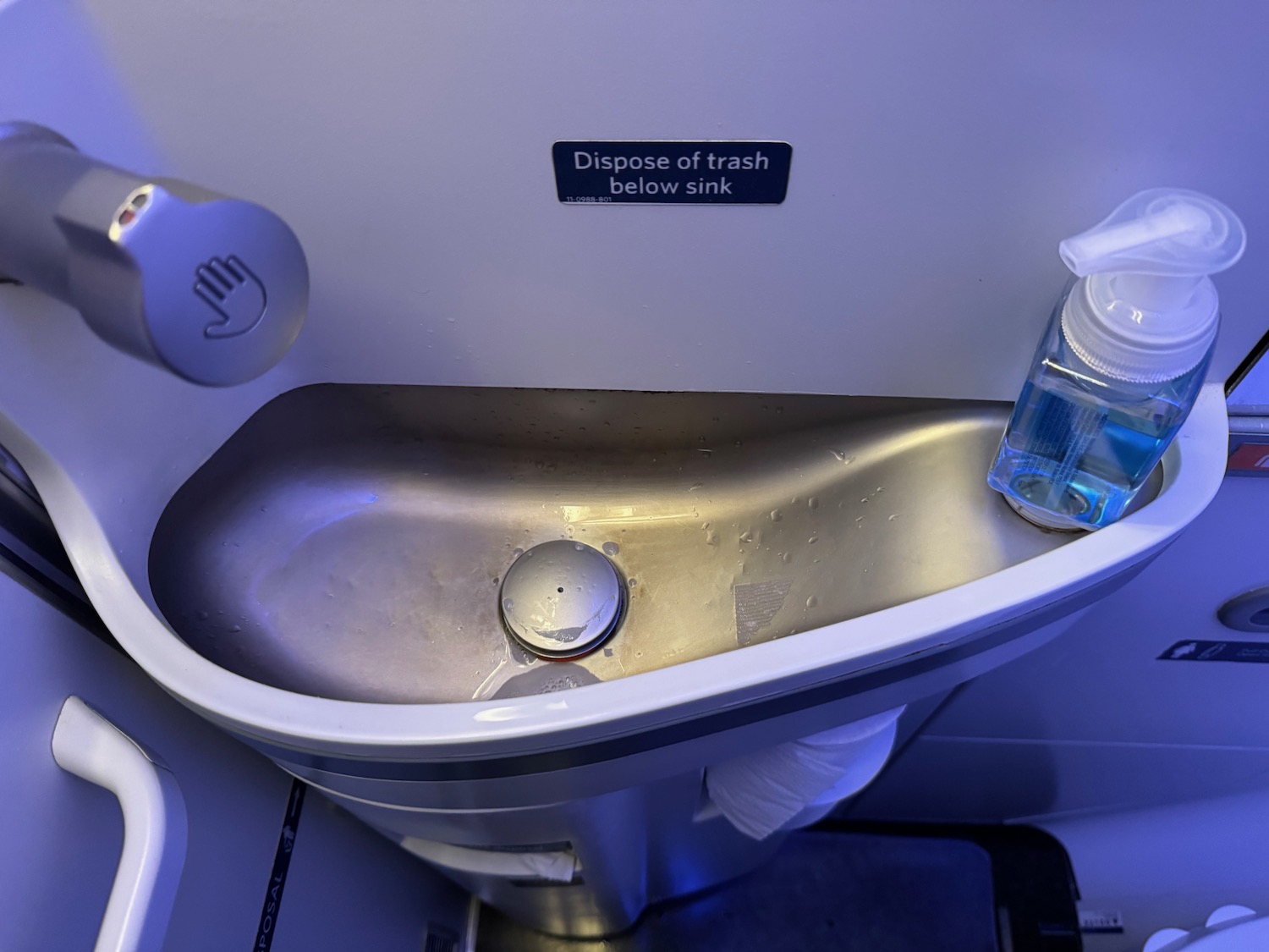 a sink with a bottle of liquid in it