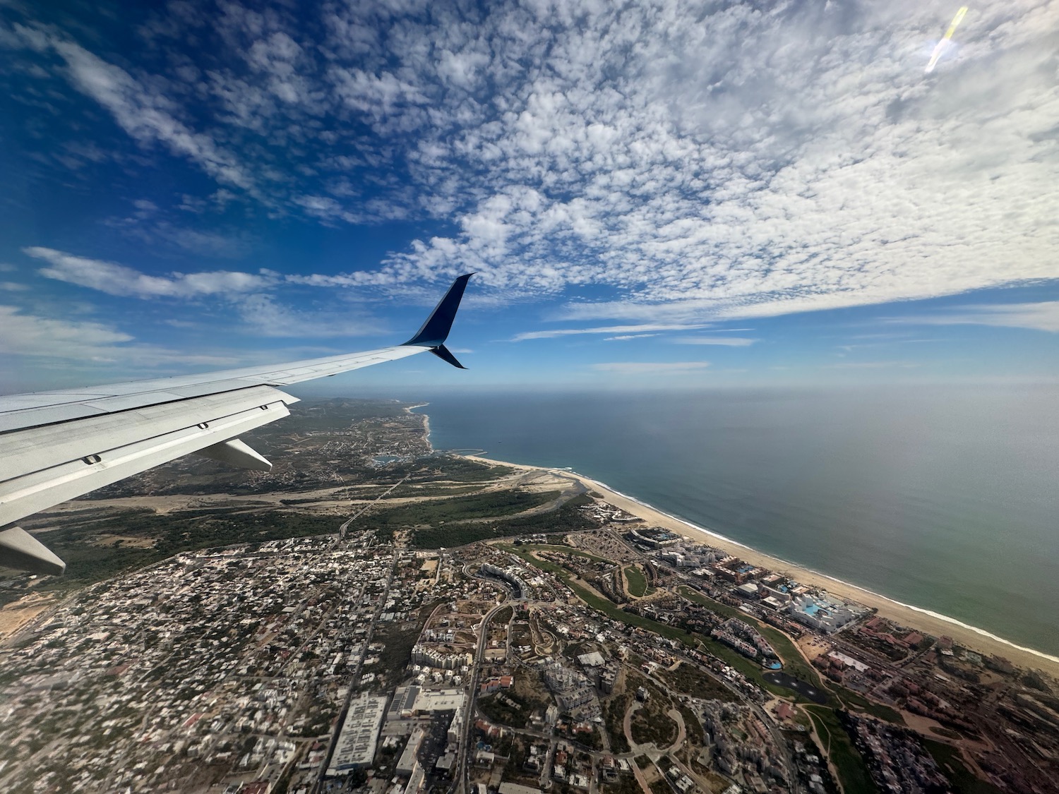 an airplane wing above a beach