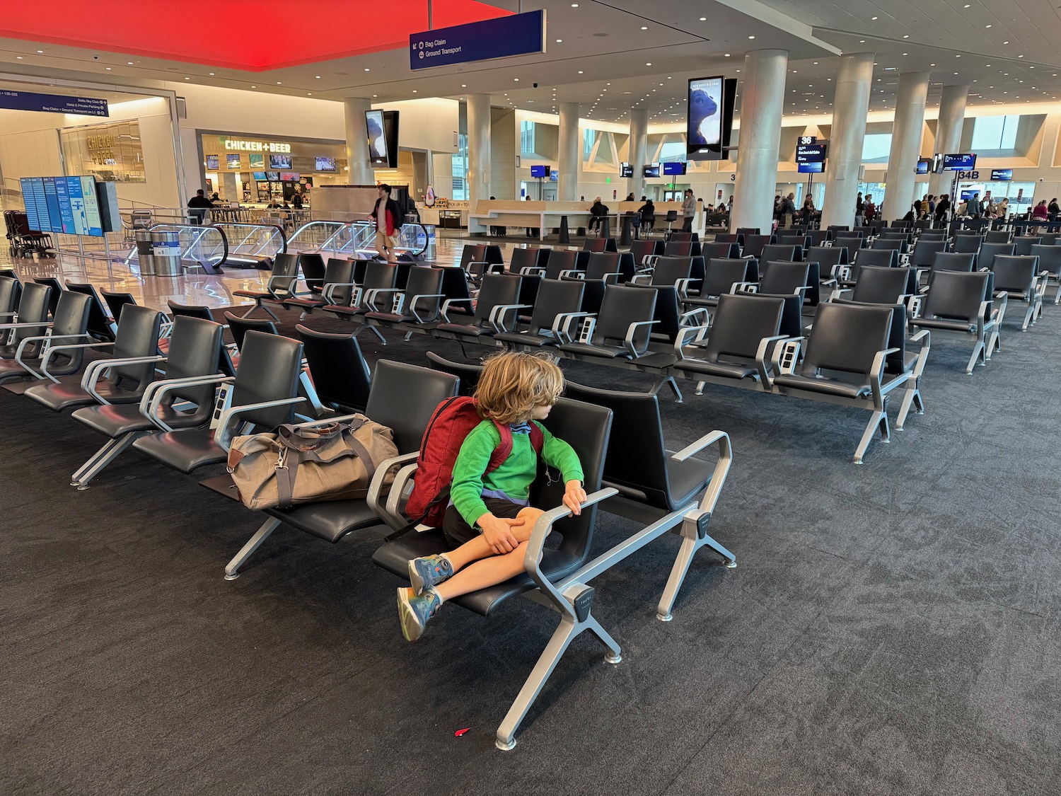 a child sitting on a chair in an airport terminal