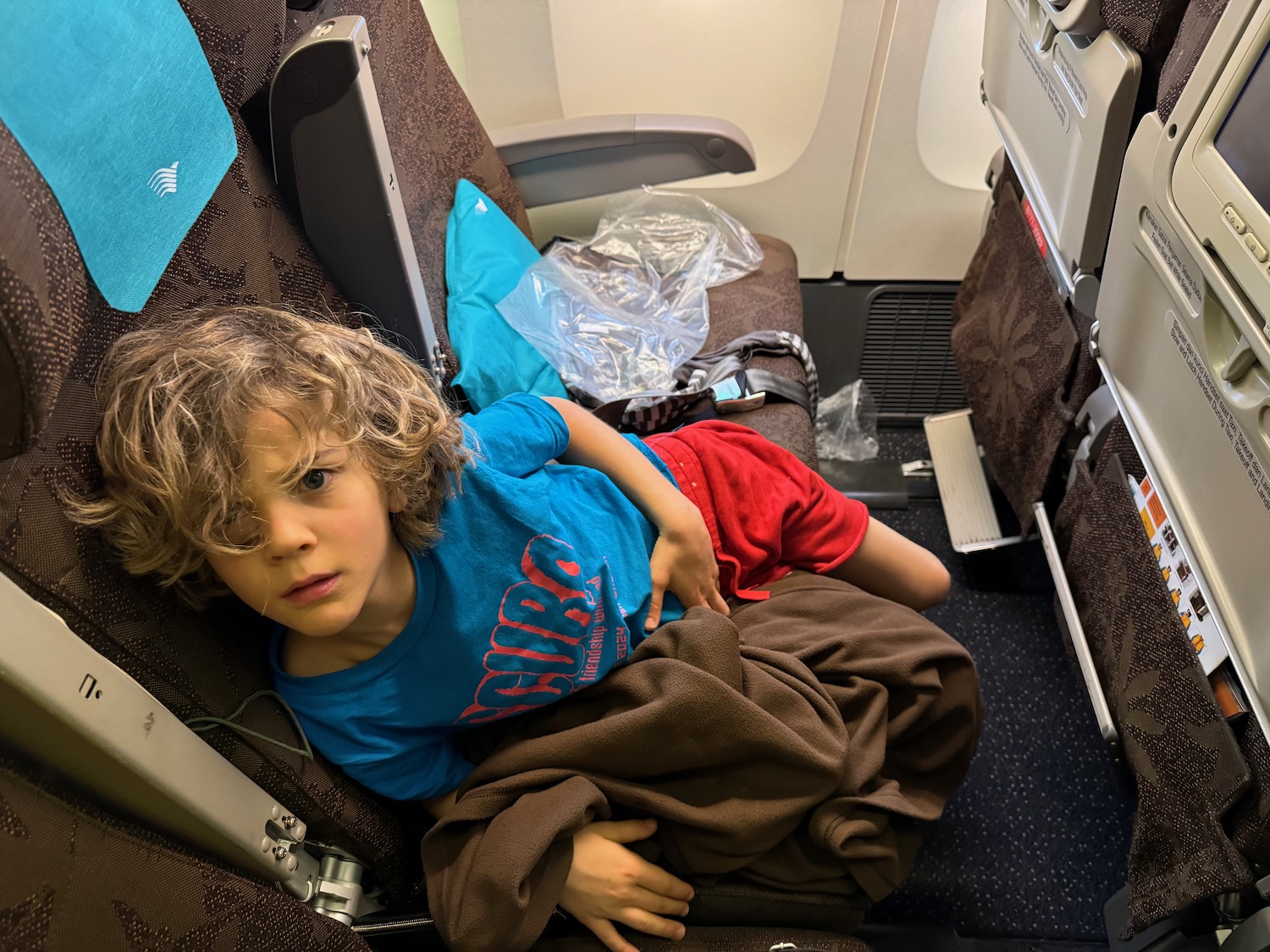 a child lying on an airplane seat