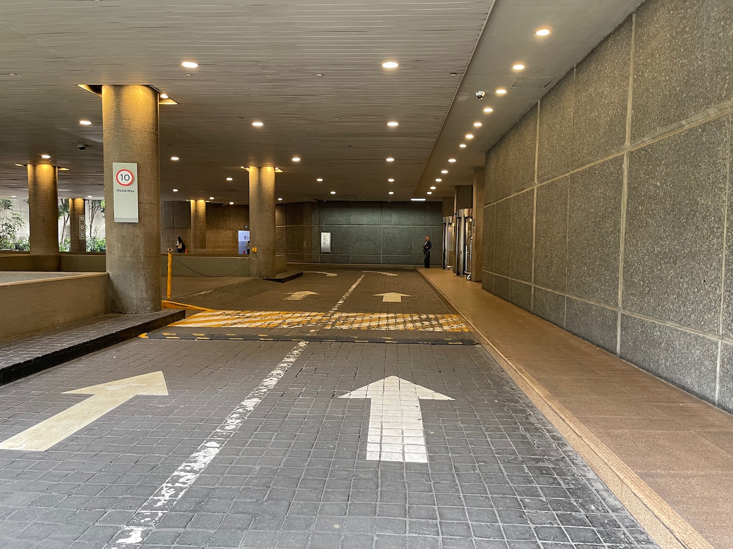 a parking garage with a man standing in front of the entrance