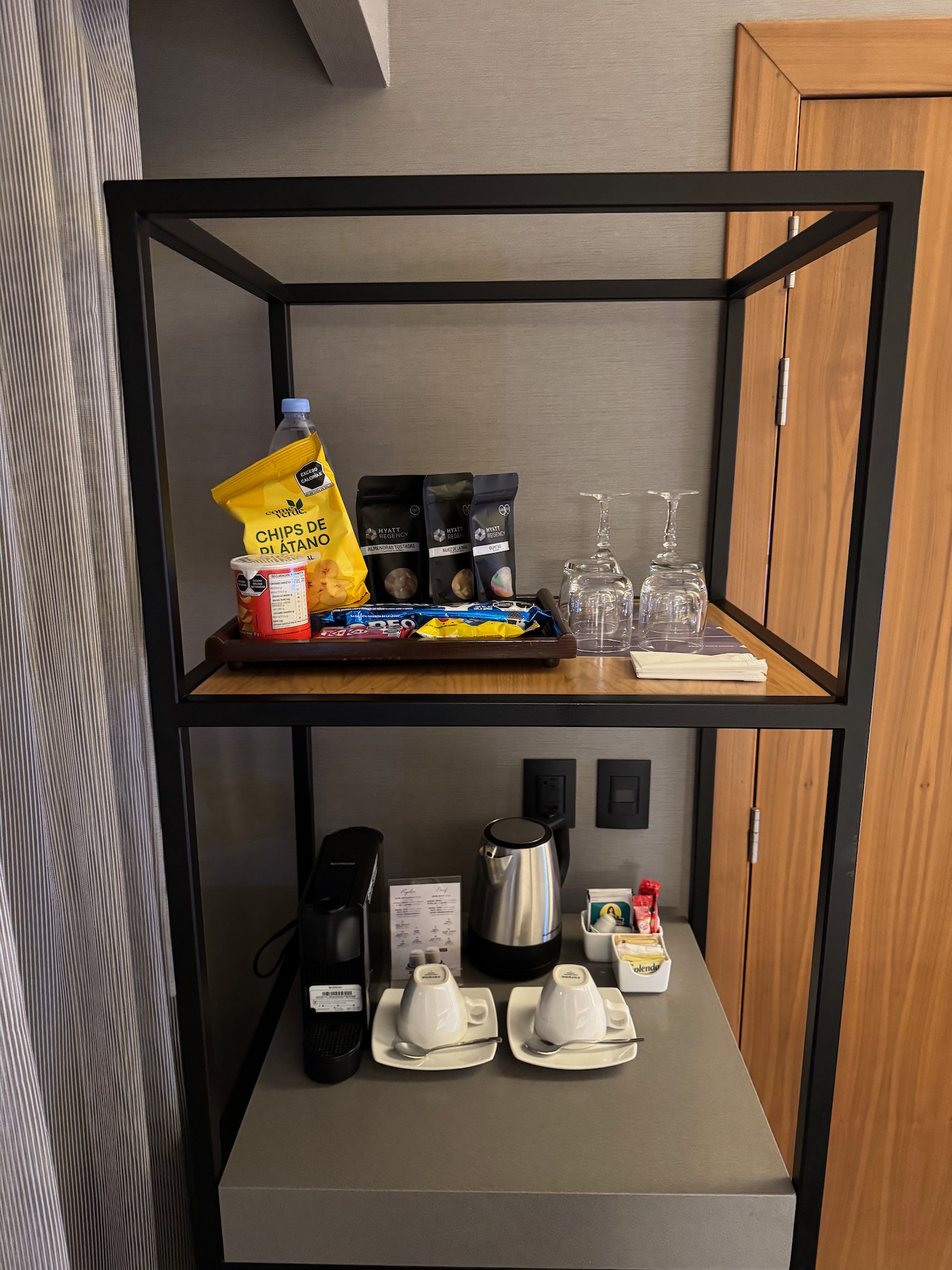 a shelf with coffee cups and snacks on it