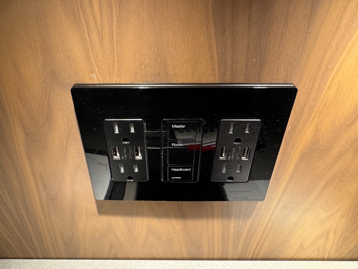 a black electrical outlet on a wood wall